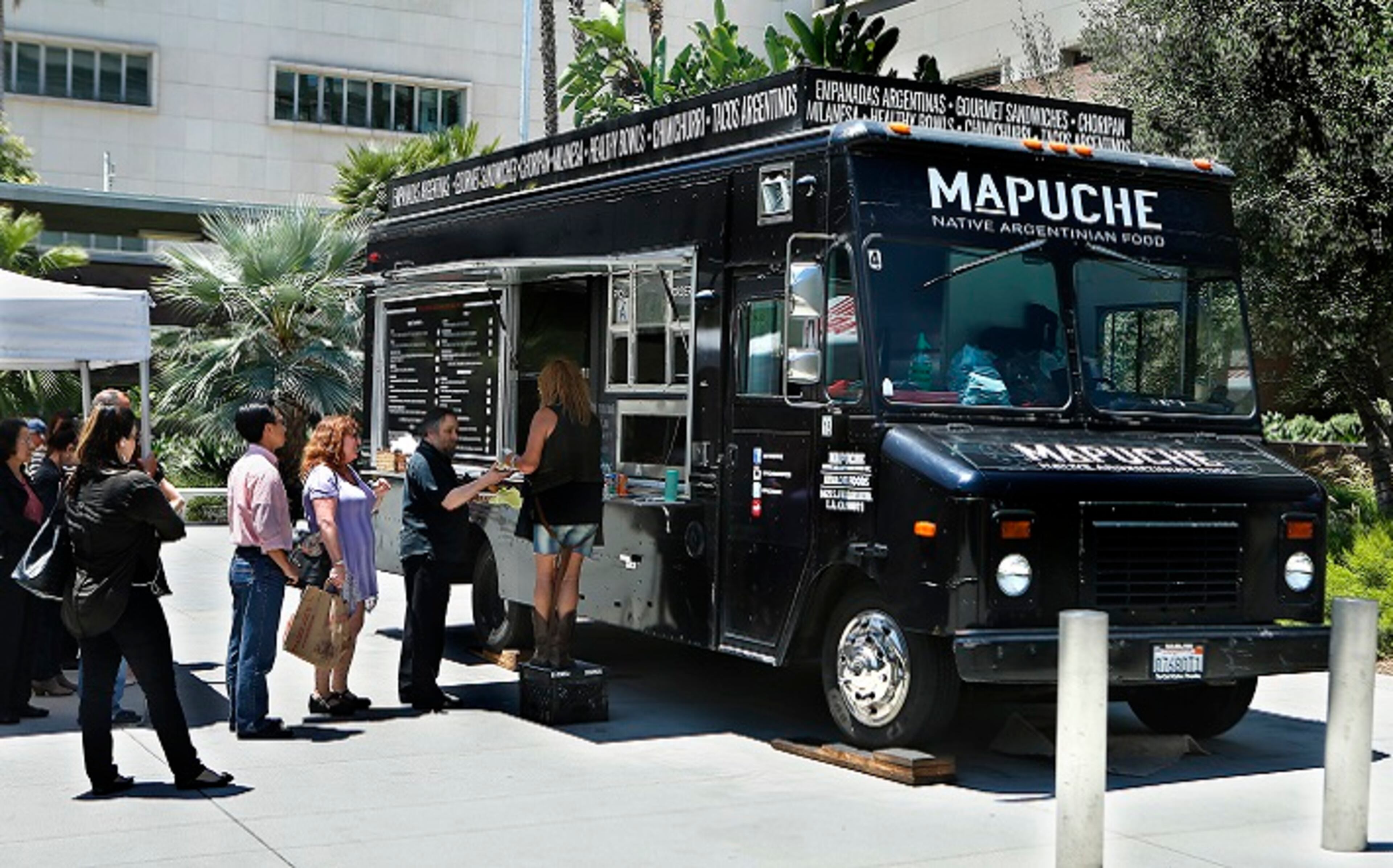 Customers wait in line at Mapuche, an Argentinian food truck, parked at Grand Park in downtown Los Angeles on July 26, 2017. (Mel Melcon/Los Angeles Times/TNS)