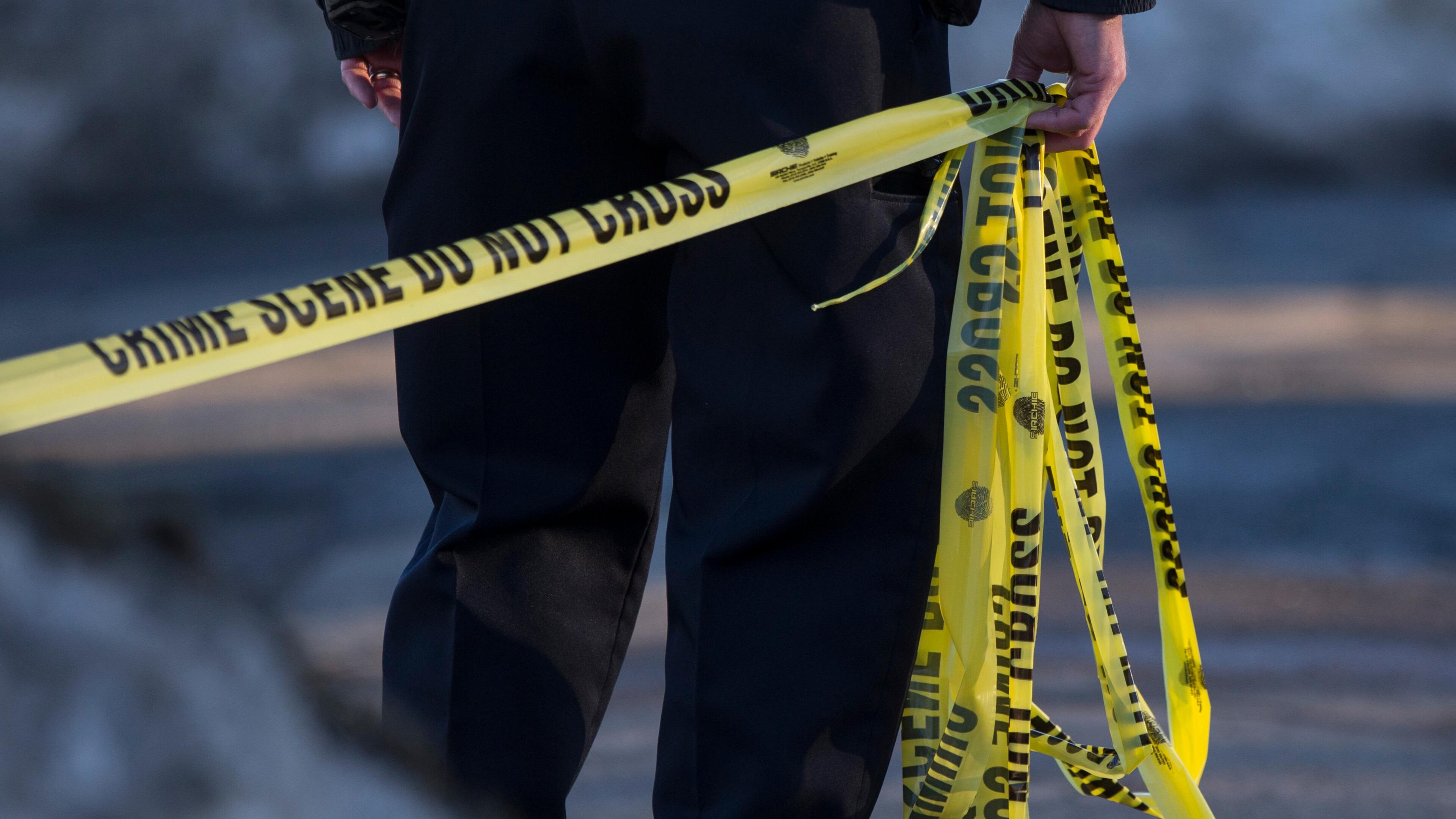 PEABODY, MA - FEBRUARY 19: A police officer pulls crime scene tape at a house where a double homicide was being investigated in Peabody, MA on Feb. 19, 2017. (Photo by Keith Bedford/The Boston Globe via Getty Images)