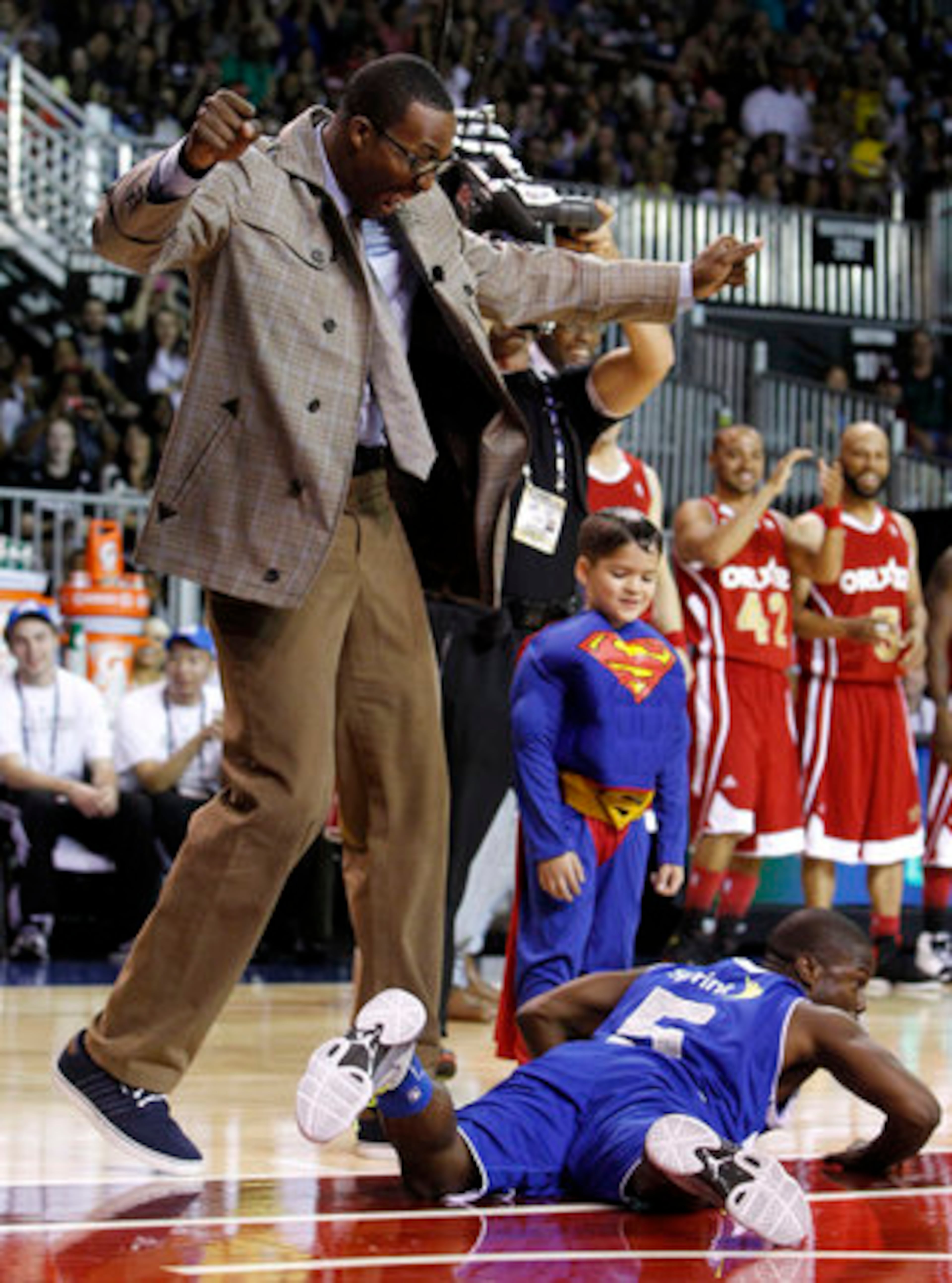 Dwight Howard laughs as comedian Kevin Hart falls to the court during an interlude from the game for some slapstick comedy.