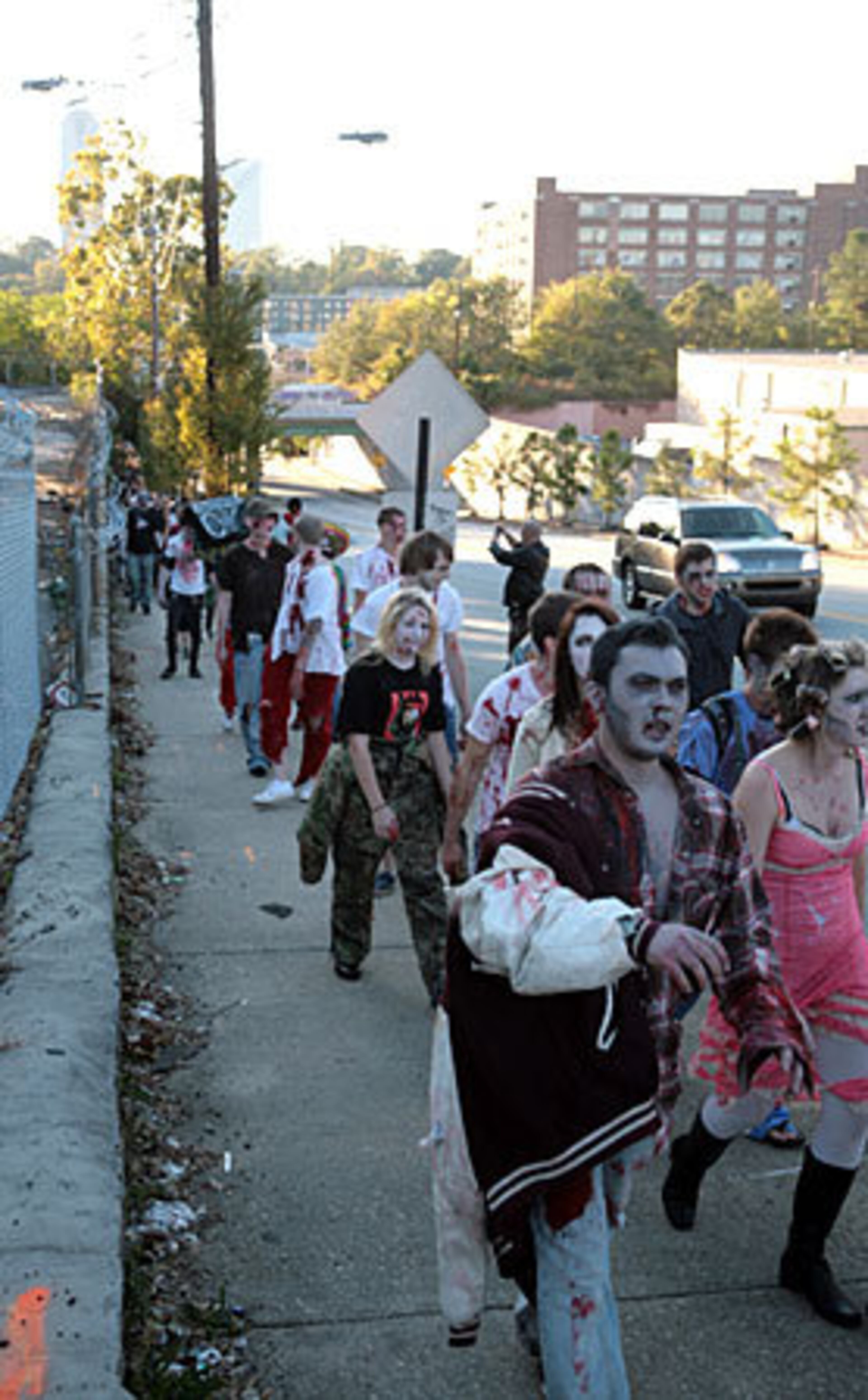 People dressed as zombies walk up North Avenue from the Masquerade toward Moreland Avenue.