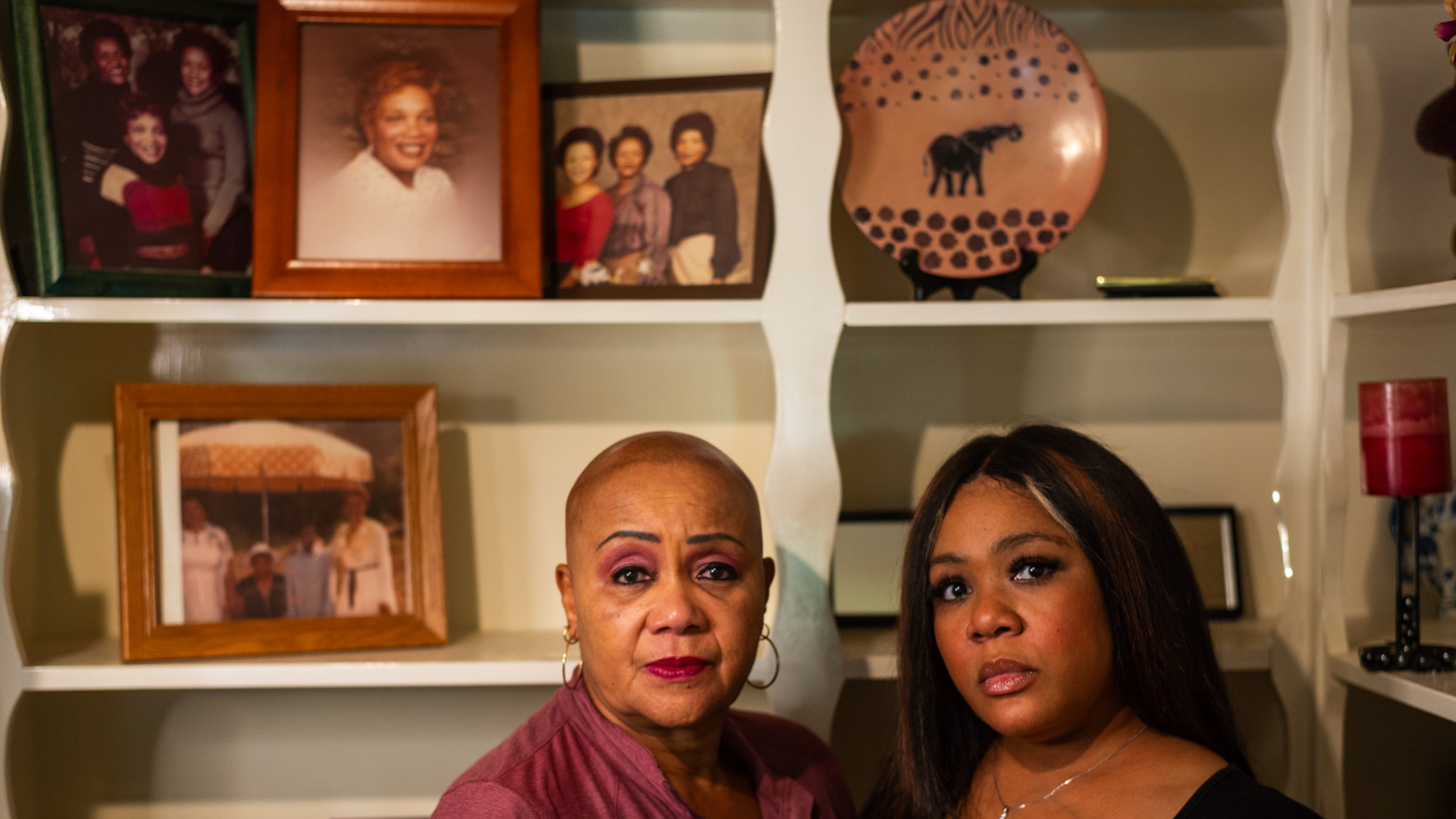 Melba McKnight (left) and Amber Lett-Hammond, in front of a wall of family photos featuring Shirley McKnight, who was killed Nov. 24, 1994.