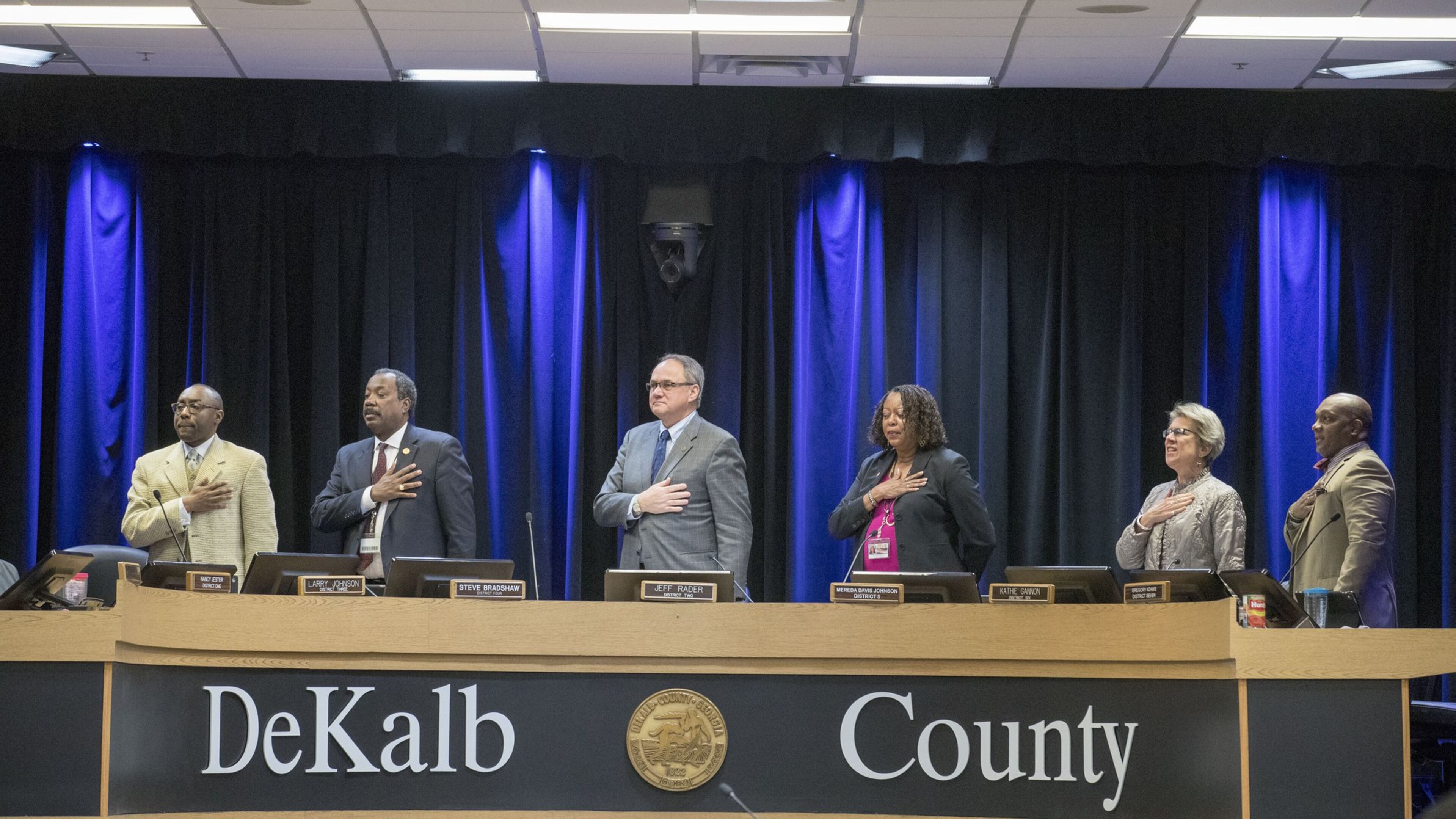 Members of the DeKalb Board of Commissioners stand for the Pledge of Allegiance before the start of a meeting on March 13. ALYSSA POINTER/ALYSSA.POINTER@AJC.COM