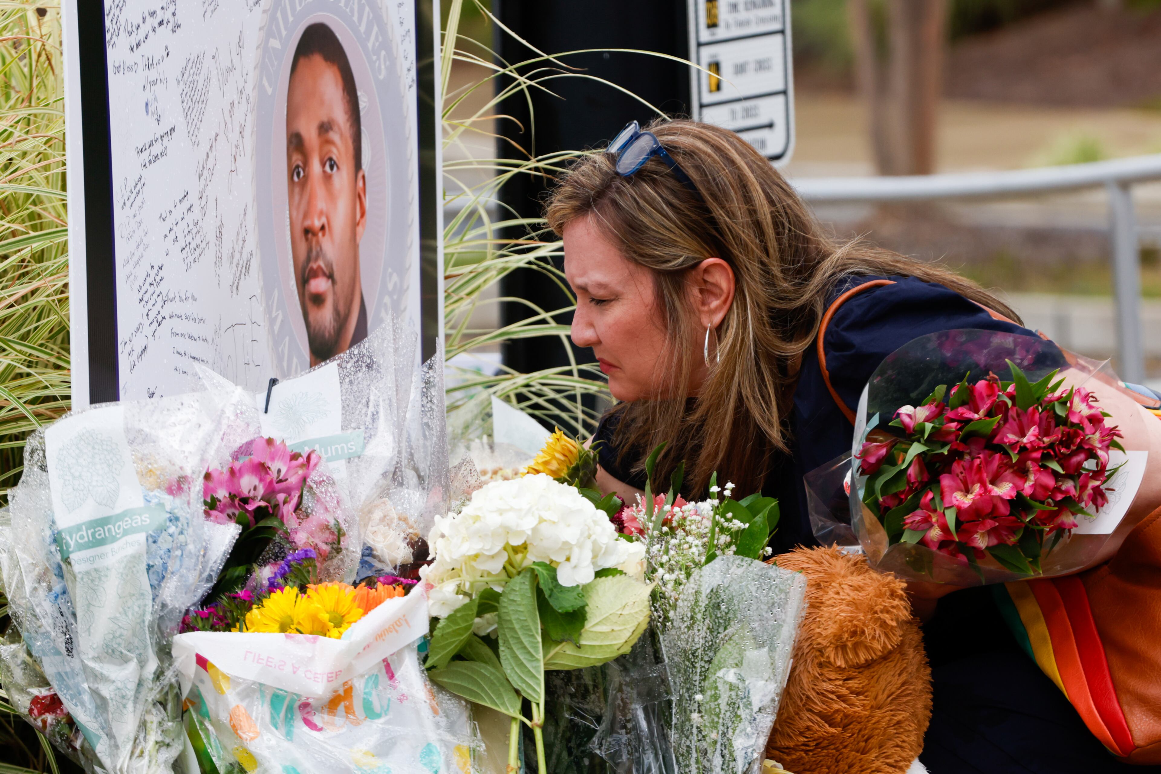 Melanie Vaughn-Coldwell pays respects at a memorial to fallen DeKalb County police Officer David Rose outside the Centers for Disease Control and Prevention headquarters in Atlanta. (Arvin Temkar/AJC)