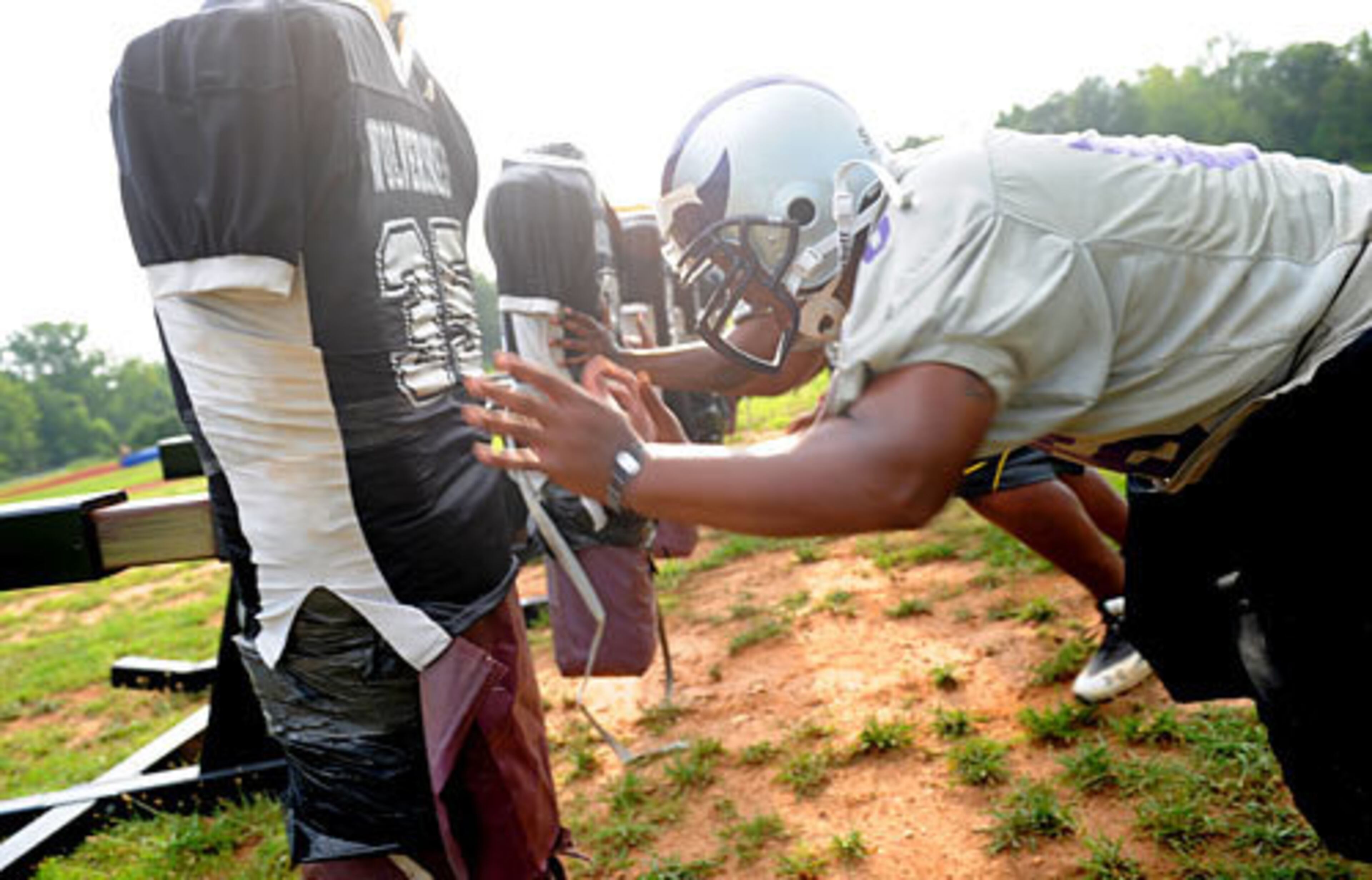Miller Grove's Demetrius Greenwood collides with the block during drills.