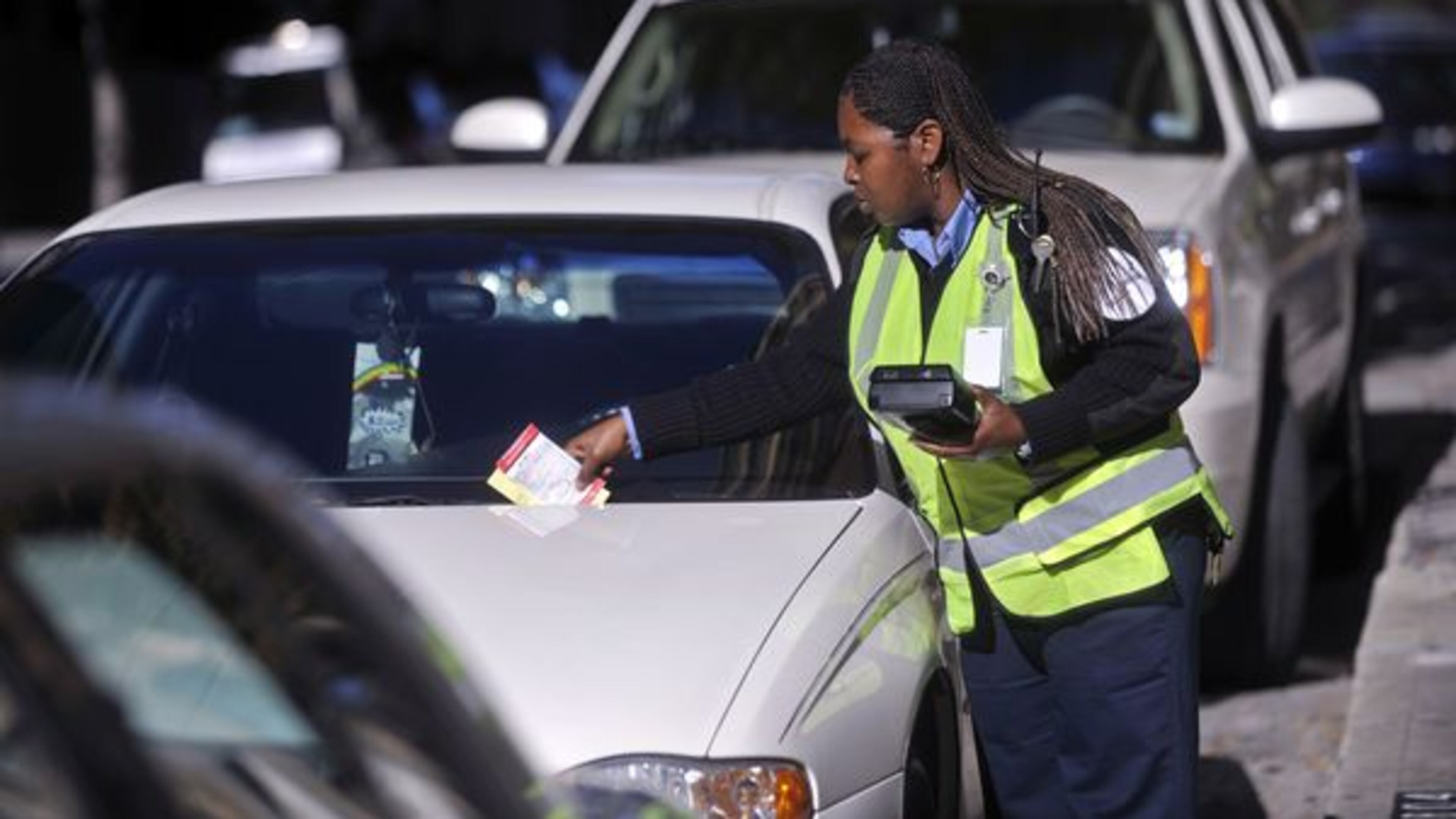 PARKAtlanta parking management agent Adrianne Shoemake-Lovett leaves a ticket on the windshield of a car with an expired metered space on Walton Street in downtown Atlanta on Nov. 9, 2010. (AJC FILE PHOTO)