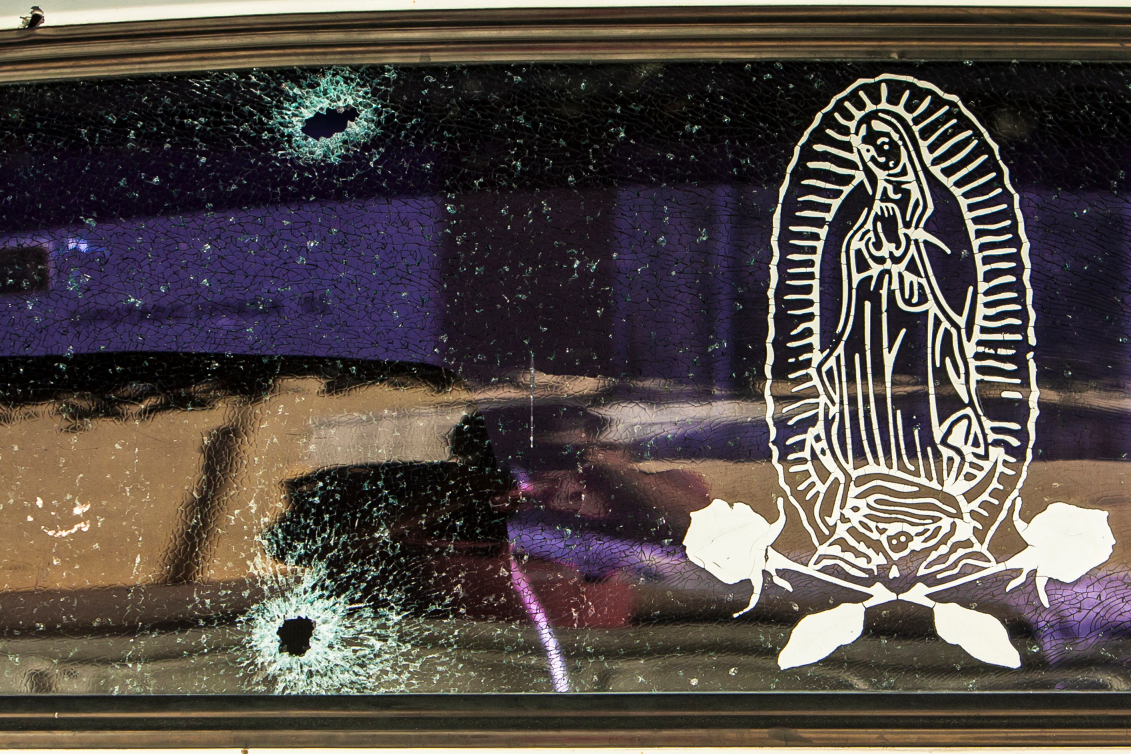 The rear windshield of a vehicle is held together by a transparent film with an image of the Virgin of Guadalupe, after being struck by a couple of bullets in Culiacan, Mexico, Tuesday, Feb. 7, 2017. The Sinaloa state prosecutorÕs office said in a statement that several suspects and a Mexican marine died in an early morning clash after heavily armed men attacked the marines while on patrol in the city. (AP Photo/Rashide Frias)