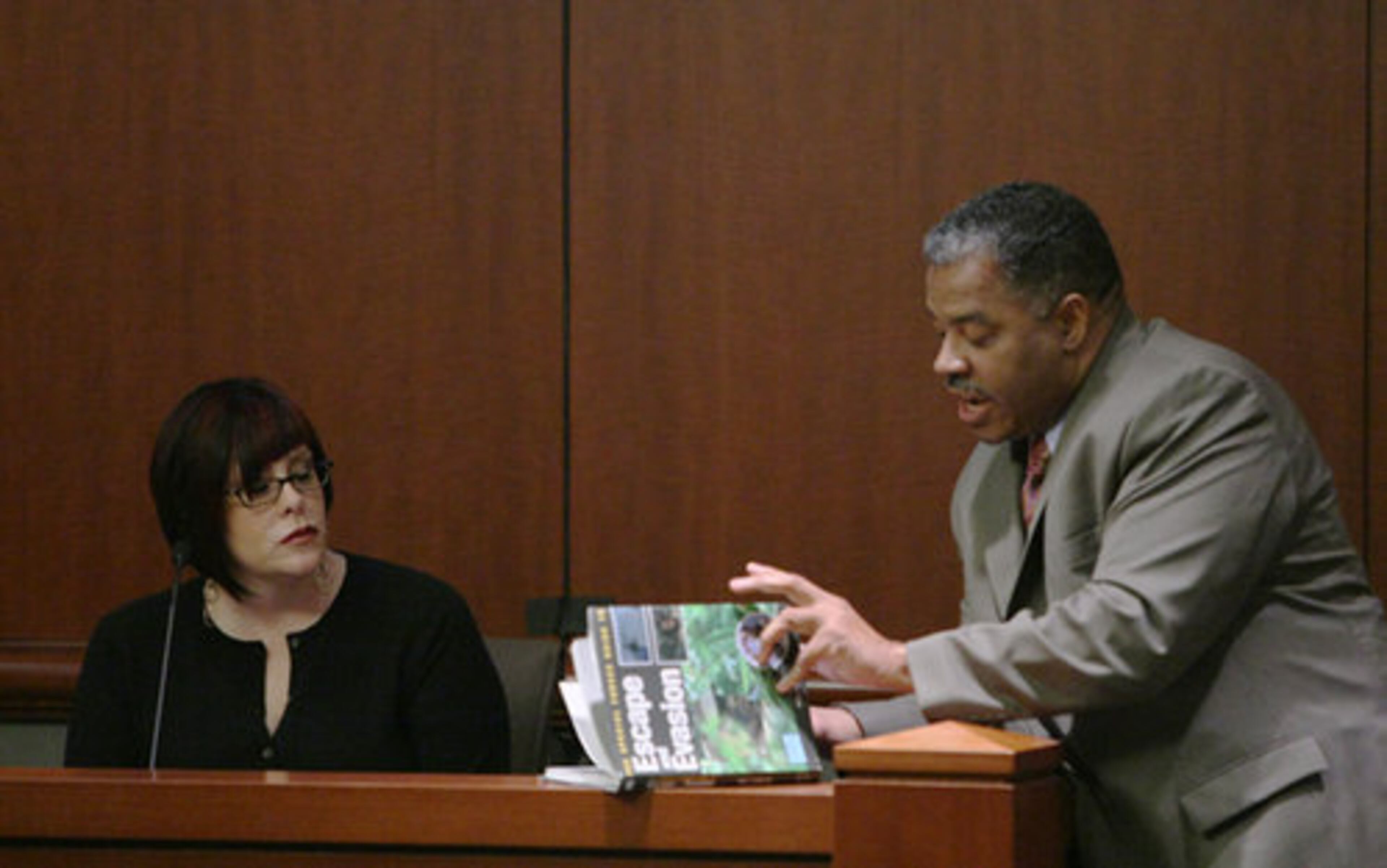 Lisa Meneguzzo looks at Henderson Hill holding the book "Escape and Evasion" during the Brian Nichols' trial. The book was one Nichols wanted Meneguzzo to get for him, she said.