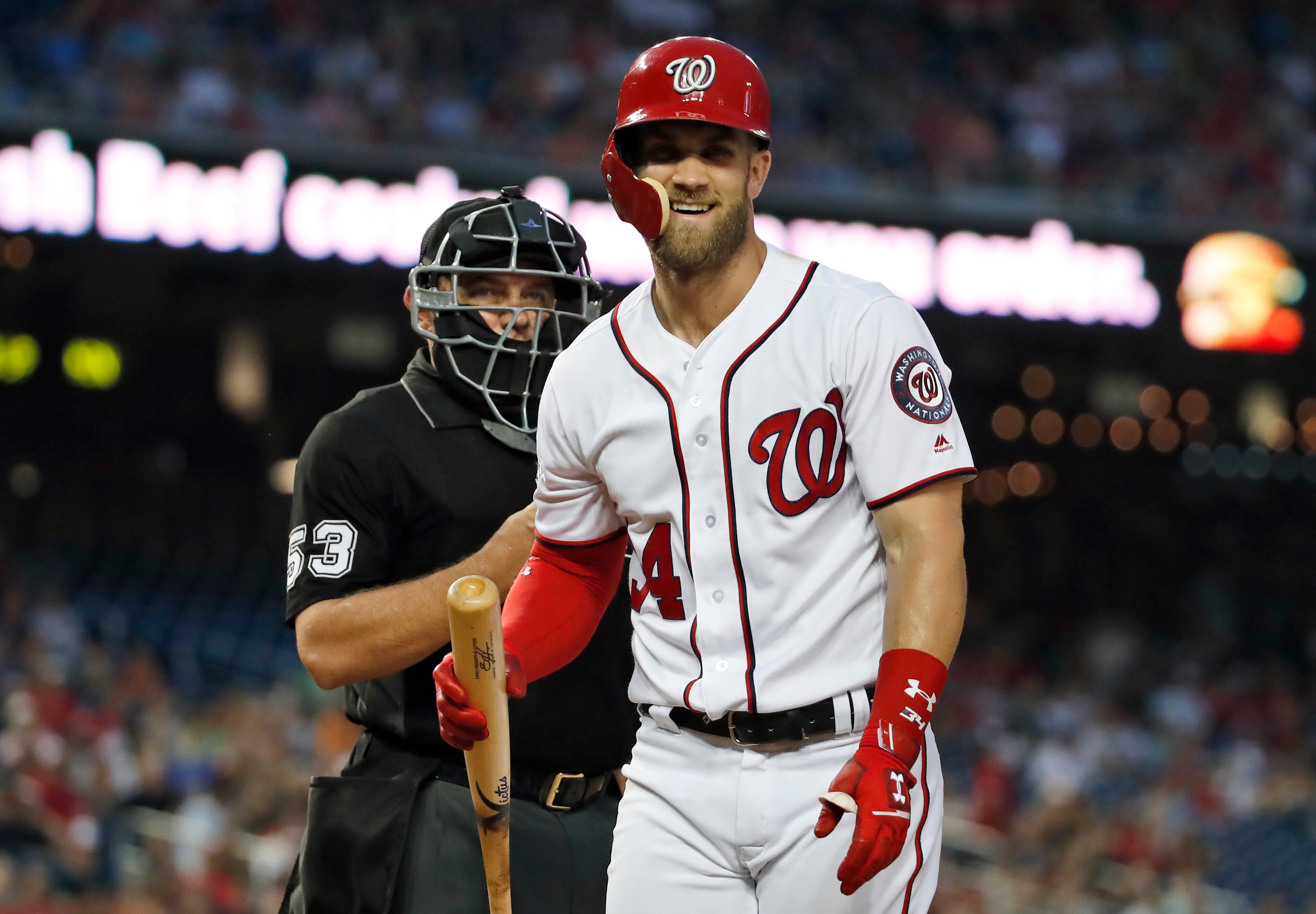 Washington Nationals' Bryce Harper laughs at a called third strike by home plate umpire Greg Gibson during the third inning of the team's baseball game against the Atlanta Braves at Nationals Park, Wednesday, Aug. 8, 2018, in Washington. (AP Photo/Alex Brandon)