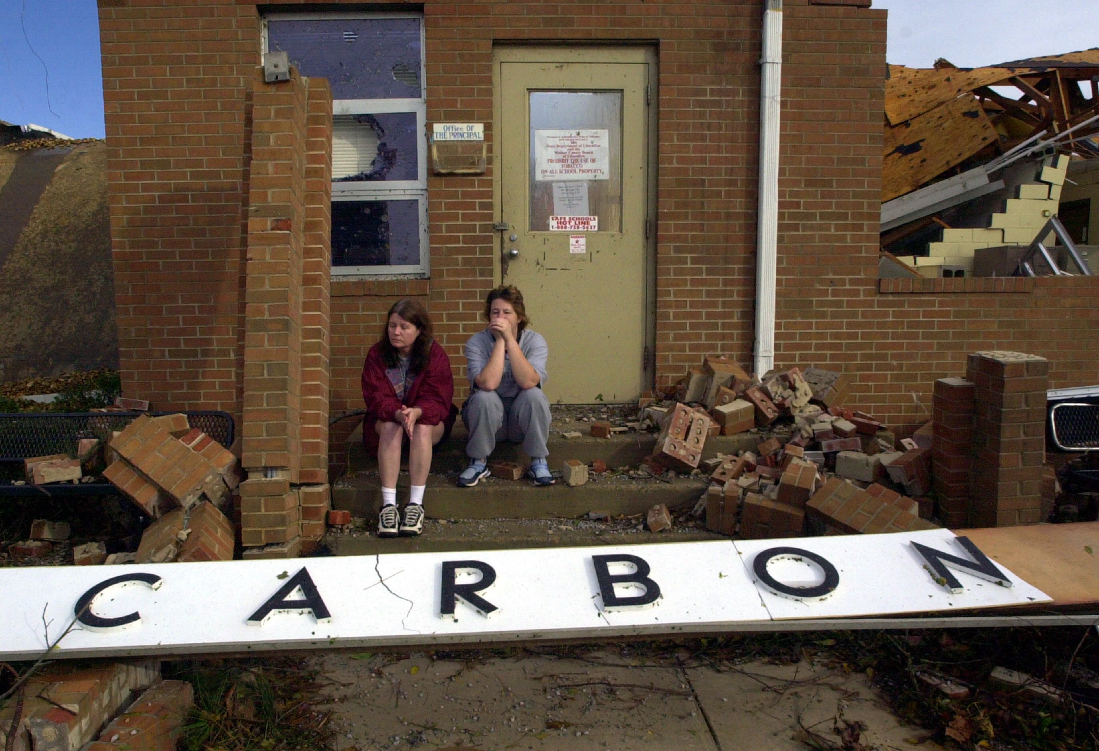 Ella Rosales, left, and Amy Dozier hold back tears as they sit on the steps to the principal's office outside the destroyed Carbon Hill Elementary School in Carbon Hill, Ala., Monday, Nov. 11, 2002. The school was heavily damaged late Sunday night when a string of tornadoes raced through the state. (AP Photo/Dave Martin)