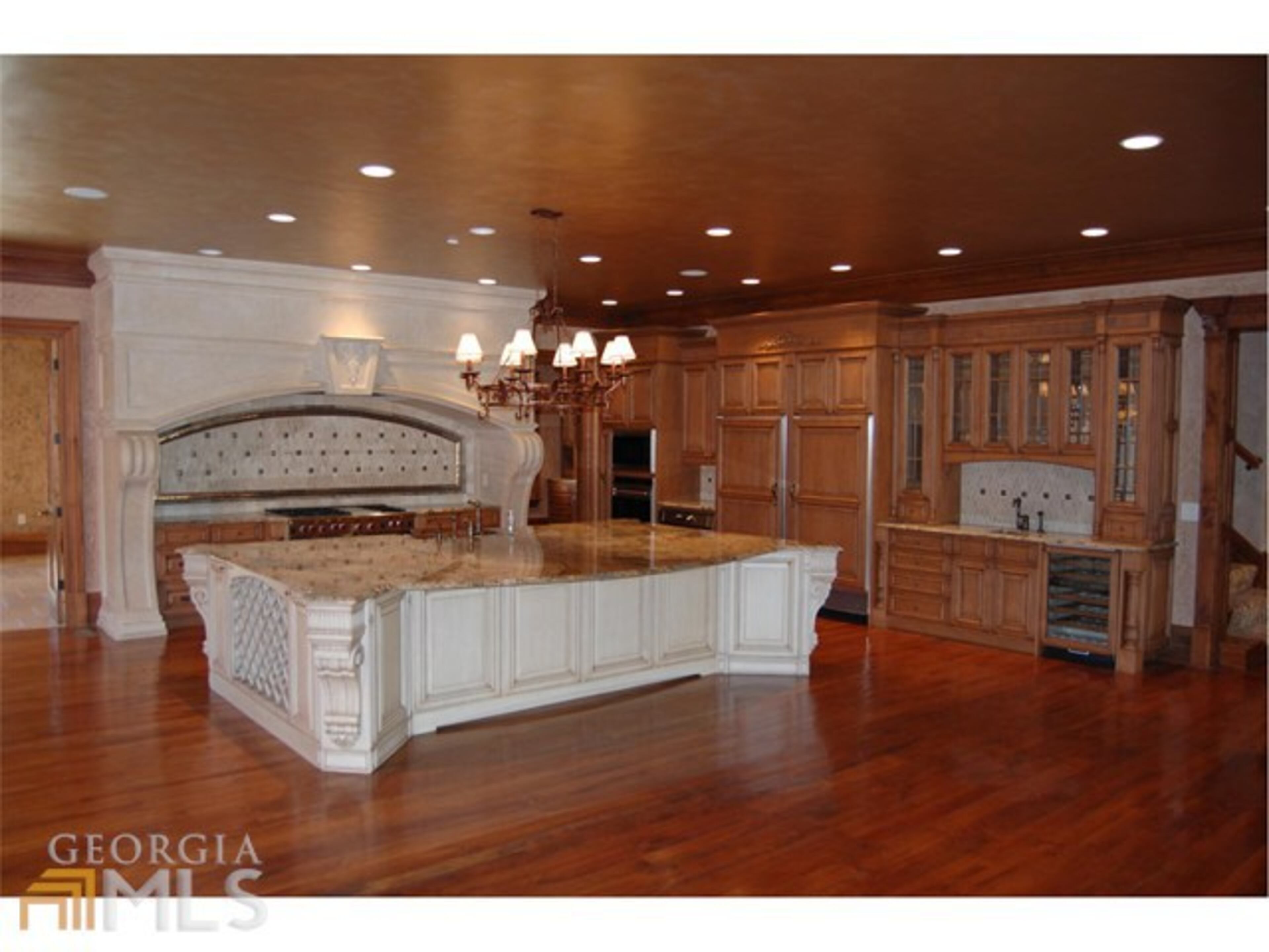 The main kitchen features a large island, a breakfast bar, and walk-in pantry.