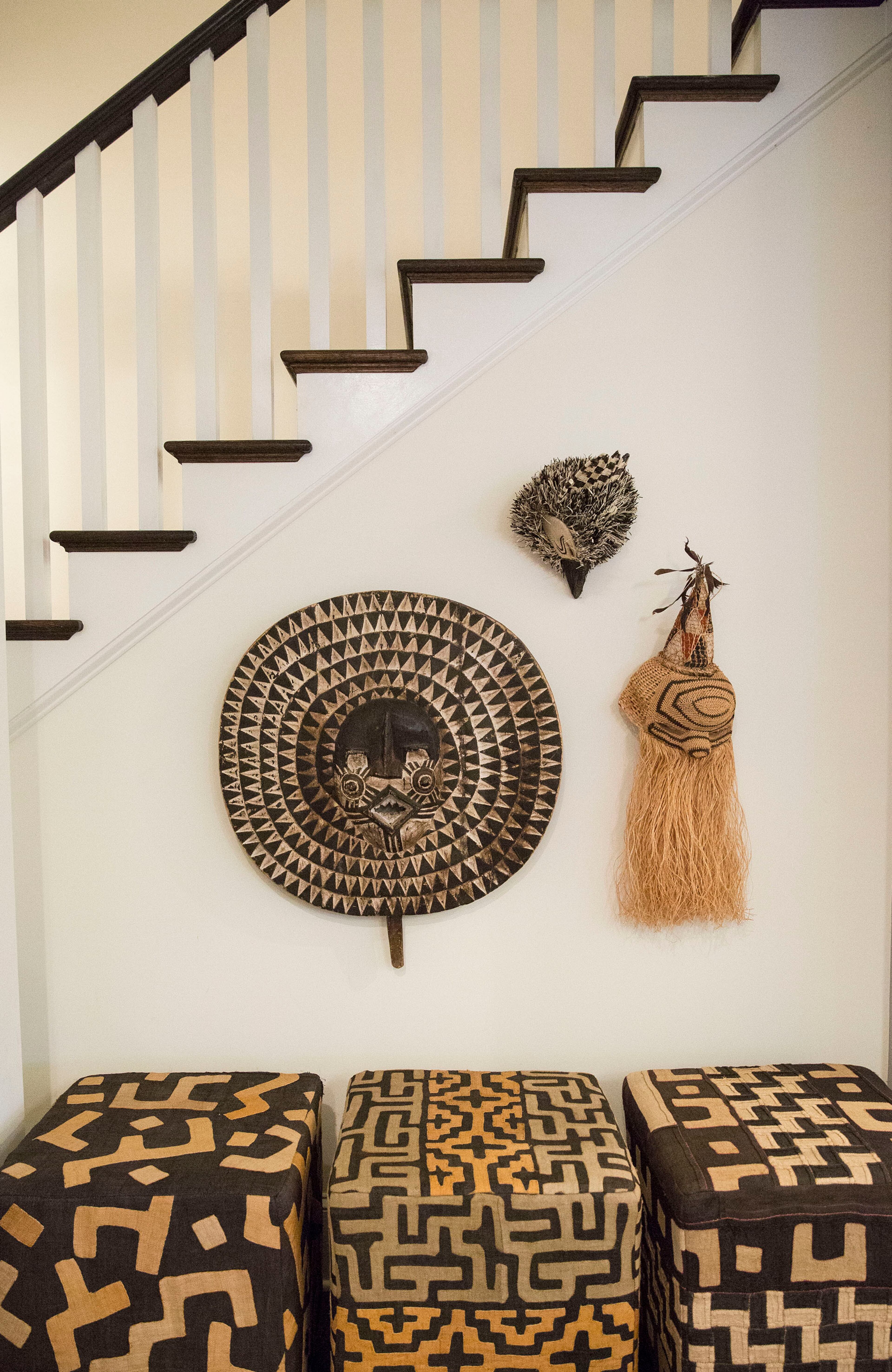 Masks and woven items from Panama, Tanzania and west Africa fill a stairwell spot in the kitchen, above ottomans covered in global and geometric prints. "It's like walking through my travels," said homeowner Judy Tabb.