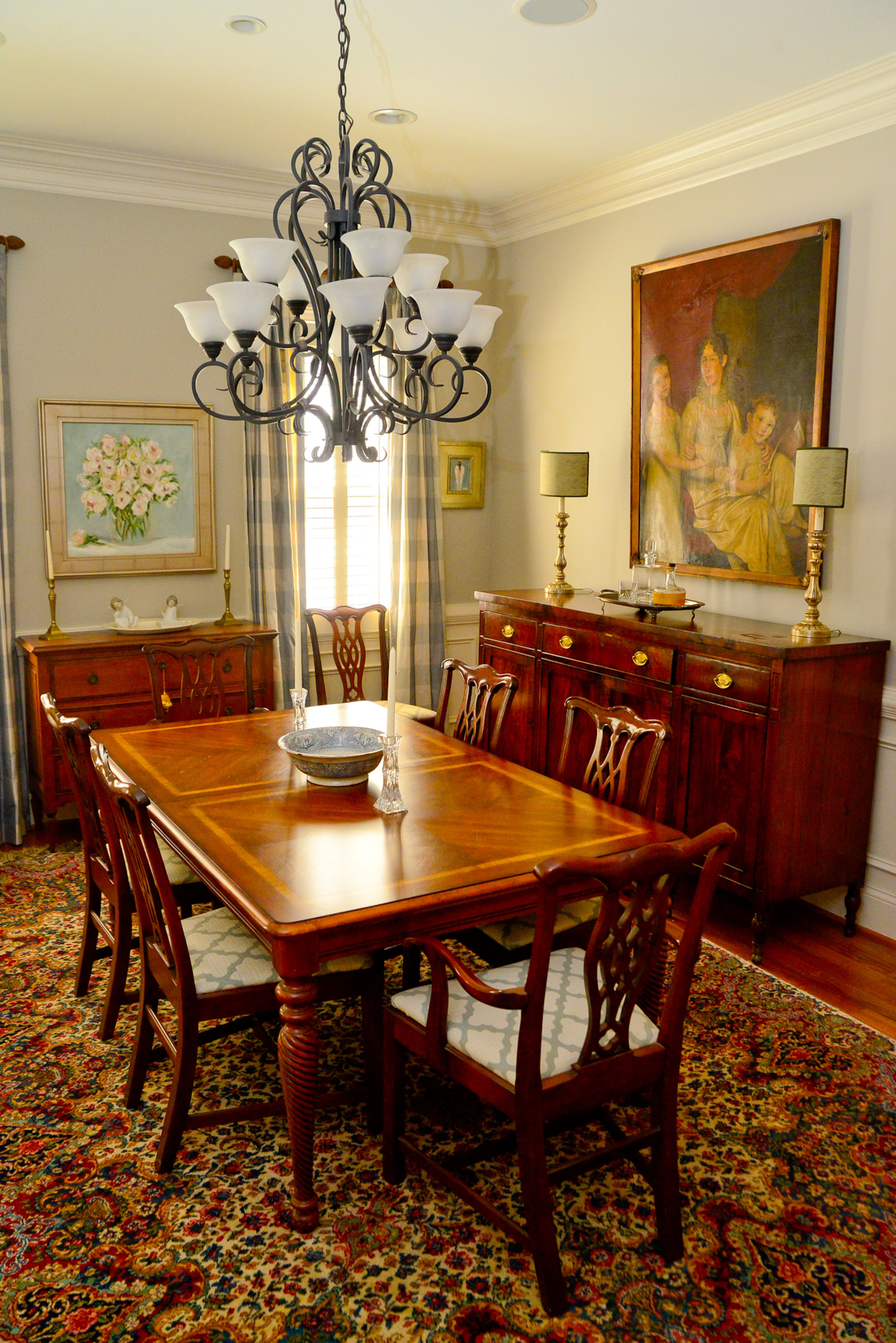 The dining room showcases some beloved paintings -- a portrait passed down from family and a floral painting by Cheryl Connelly. The table, from Beverly Hall, is paired with an antique sideboard.
