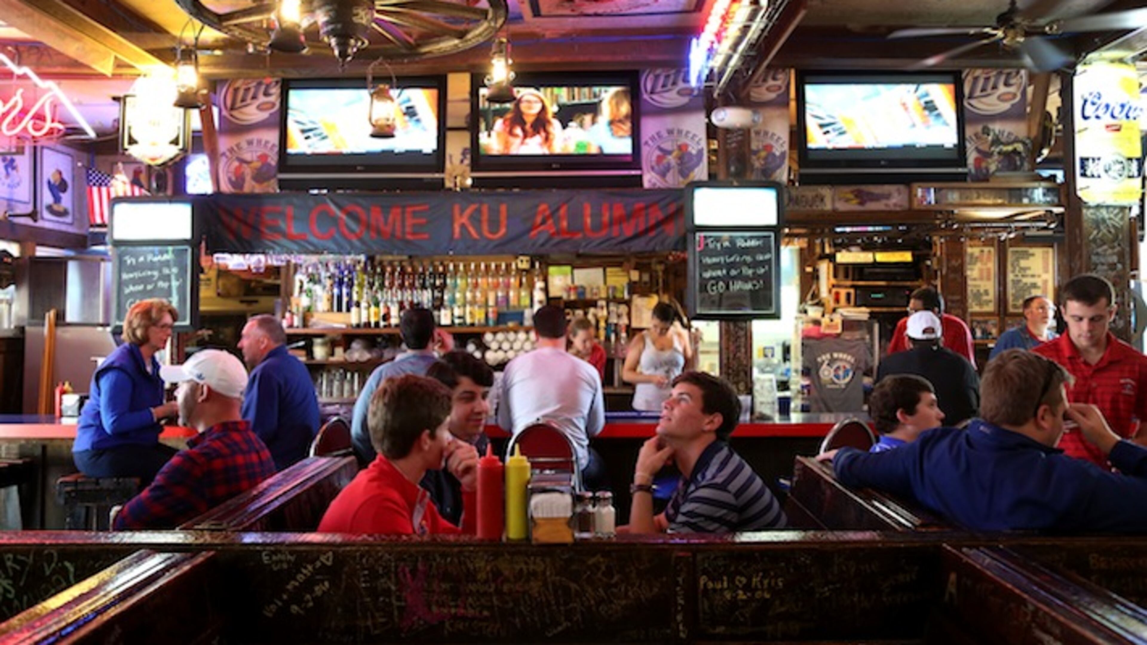 The Wheel in Lawrence, Kan., Oct. 10, 2015. Not far from the University of Kansas, the restaurant and bar, known for its wang burger and its 15 televisions, does not draw a lot of football fans when the school’s team plays (and often loses), but owner Robert Farha endures while he waits for basketball season and the customers that will come with it, eager to watch a traditional winner. (Christopher Smith/The New York Times)