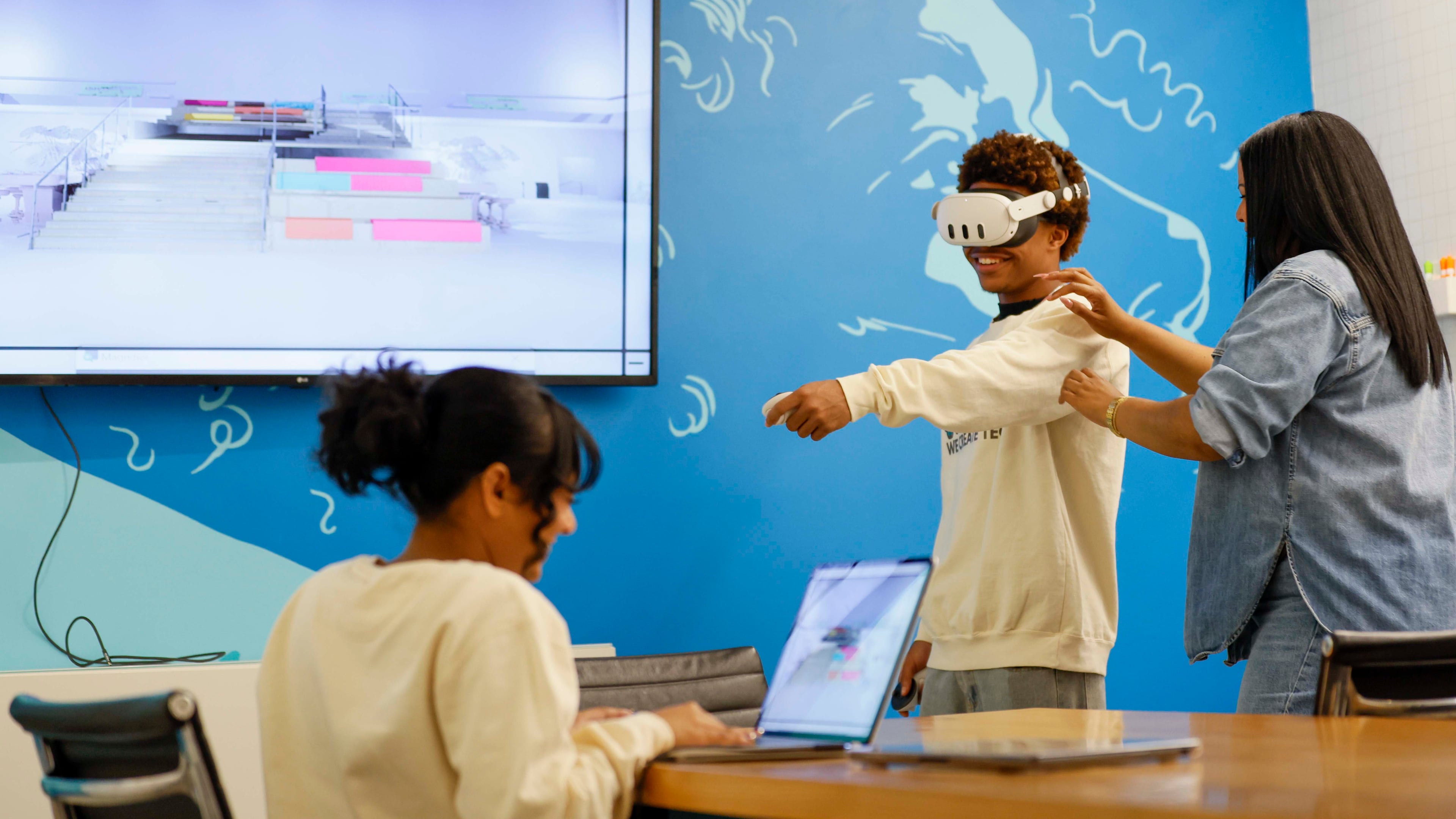 Shana Sanders, founder and CEO of We Create Tech, works with King Arrington as Natasha Narine navigates a 3D space during a VR program class at Polywood. Sanders and her team have led immersive experiences in coding and AI, and are now pioneering a culturally responsive VR education space. (Miguel Martinez/AJC 2025)