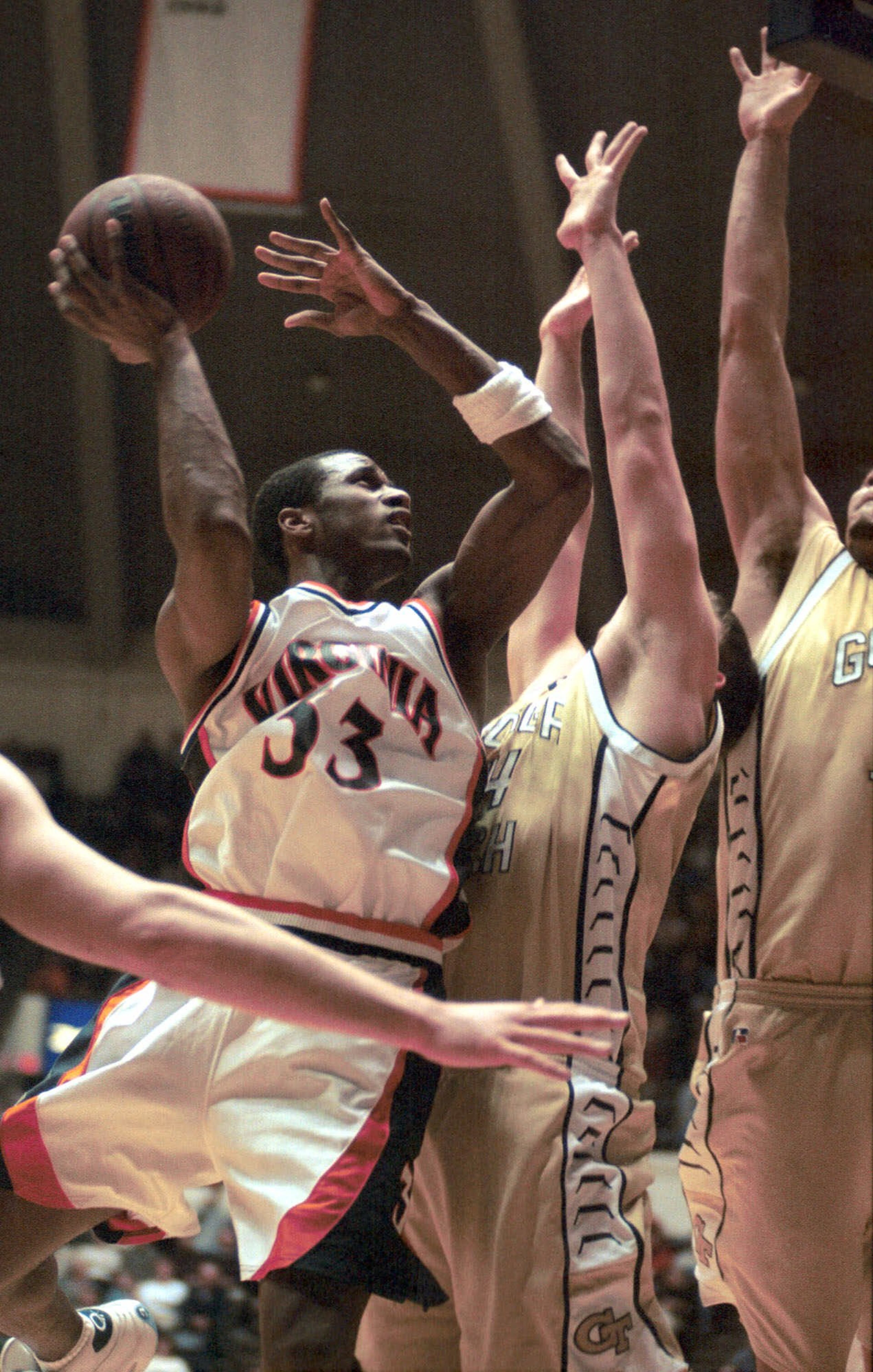 Jan. 9, 2001 -- Virginia's Chris Williams, left, takes a shot over Tech's Michael Isenhour, center, in Charlottesville, Va. BEN SCHWARTZ / THE DAILY PROGRESS