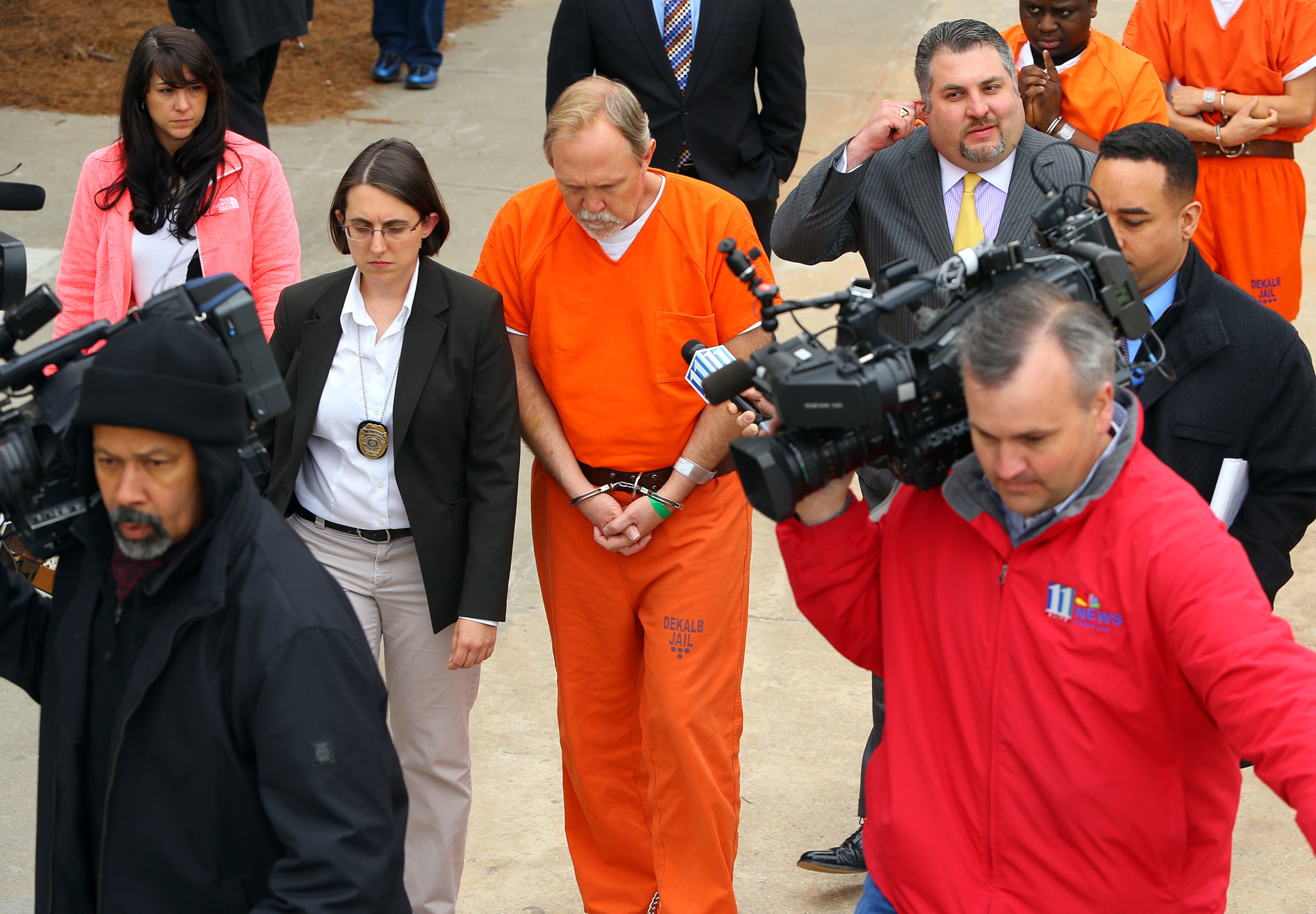John McGill, principal of Mt. Carmel Elementary School in Douglas County, is led away after his hearing at DeKalb County Magistrate Court for a felony offense of electronic pornography and child exploitation followed by the media and his attorney Mac Pilgrim on Tuesday, March 4, 2014, in Decatur.