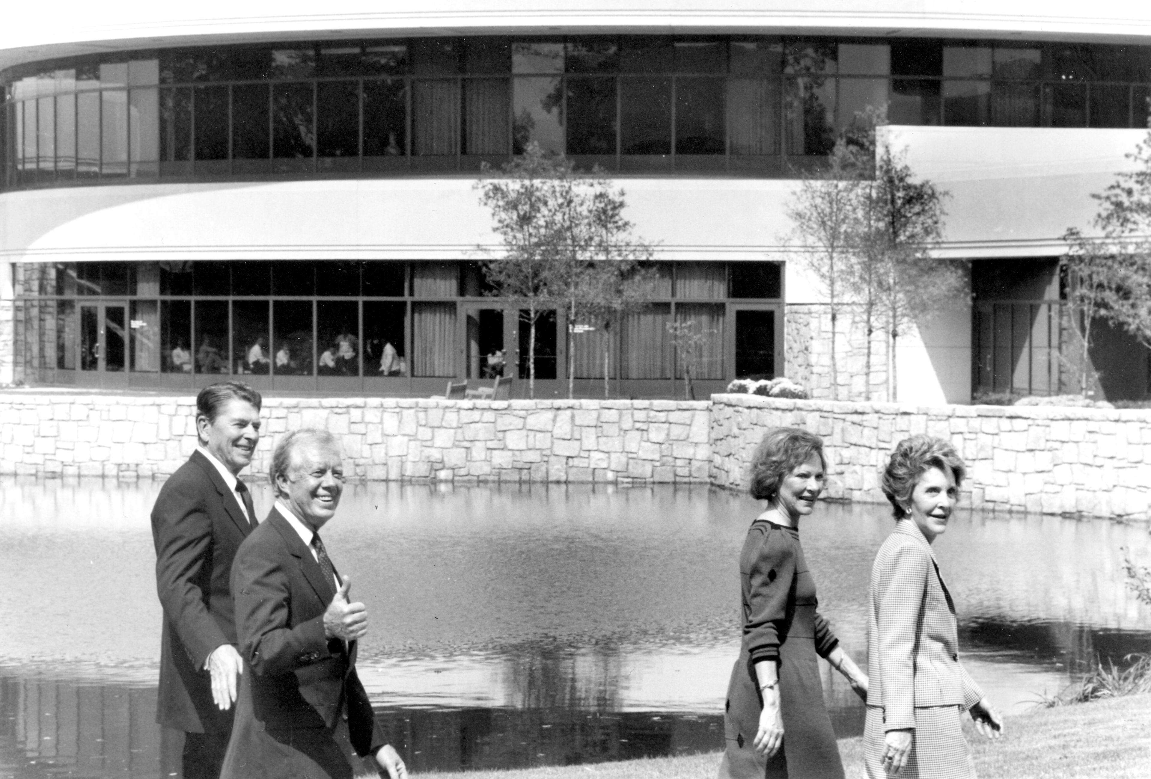 Jimmy Carter gives a thumbs-up sign as he and Rosalynn give a tour of the Carter Center to Ronald and Nancy Reagan.