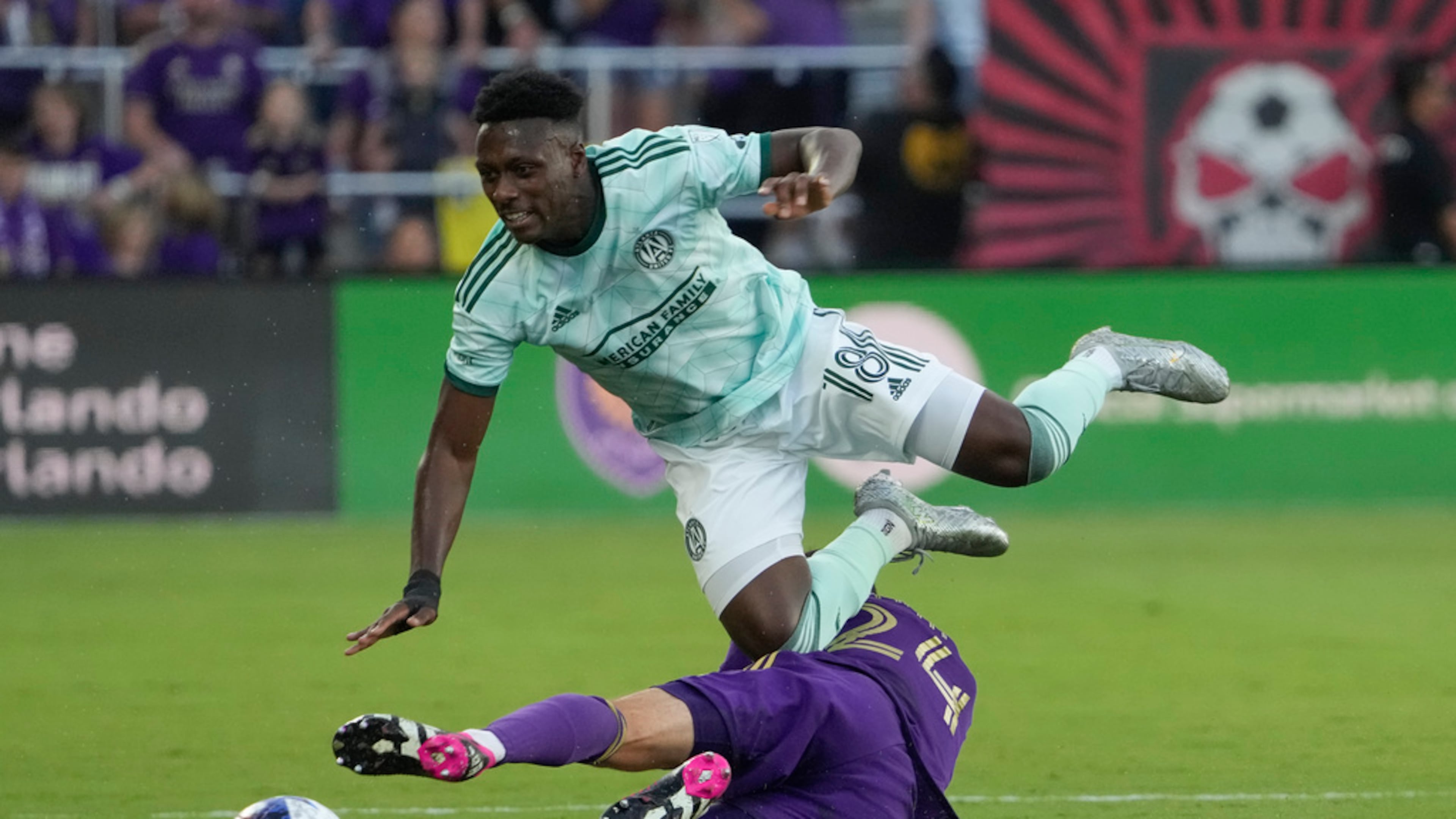 Atlanta United midfielder Derrick Etienne (18) goes over Orlando City defender Kyle Smith, bottom, as they battle for possession of the ball during the first half of an MLS soccer match, Saturday, May 27, 2023, in Orlando, Fla. (AP Photo/John Raoux)