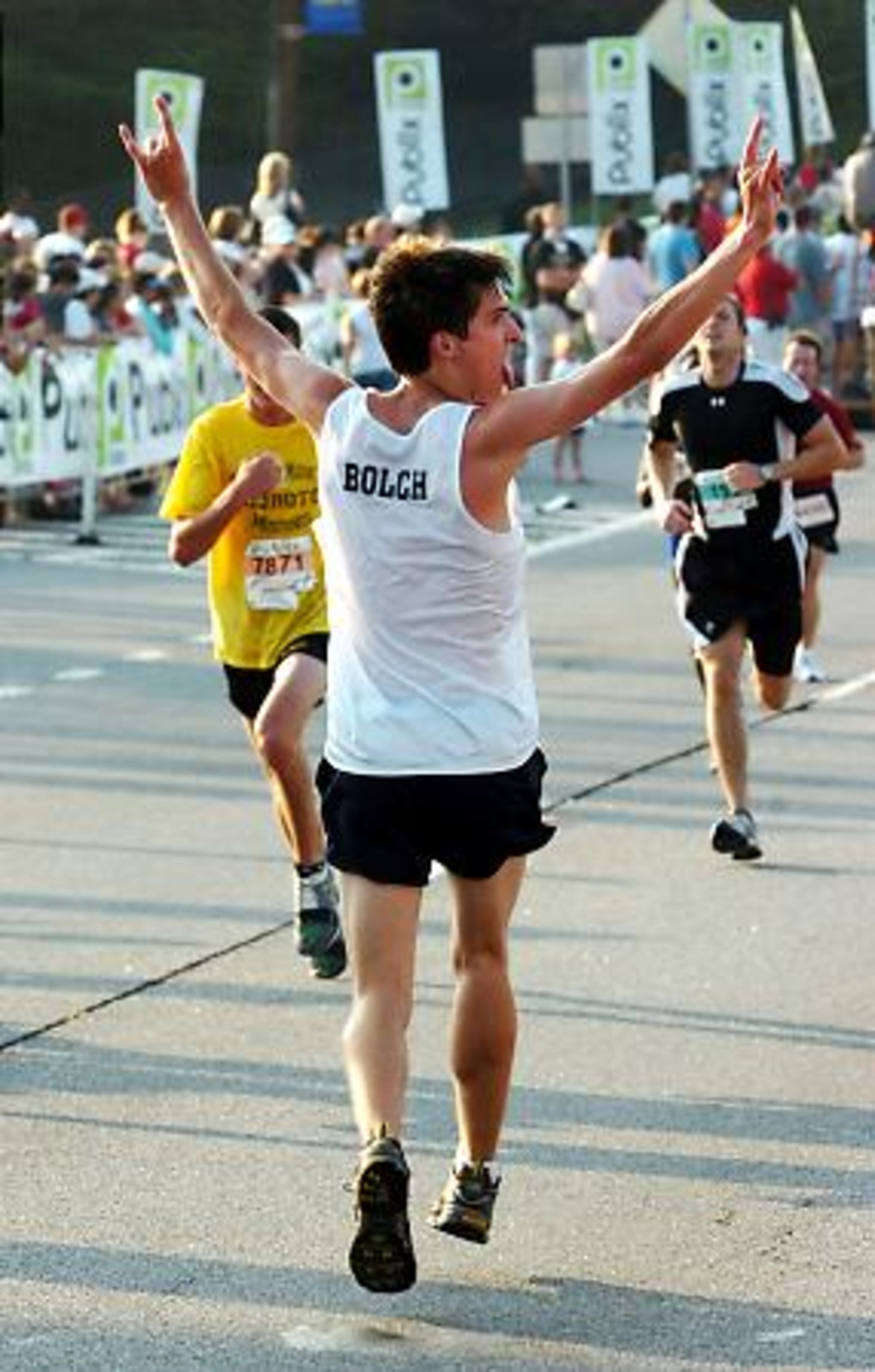 Scott Bolch, 18, of Marietta, decides to run the last yards backwards this morning -- and he did it without tripping! Bolch is a Marietta High graduate who now attends Auburn University and competes in triathlons.