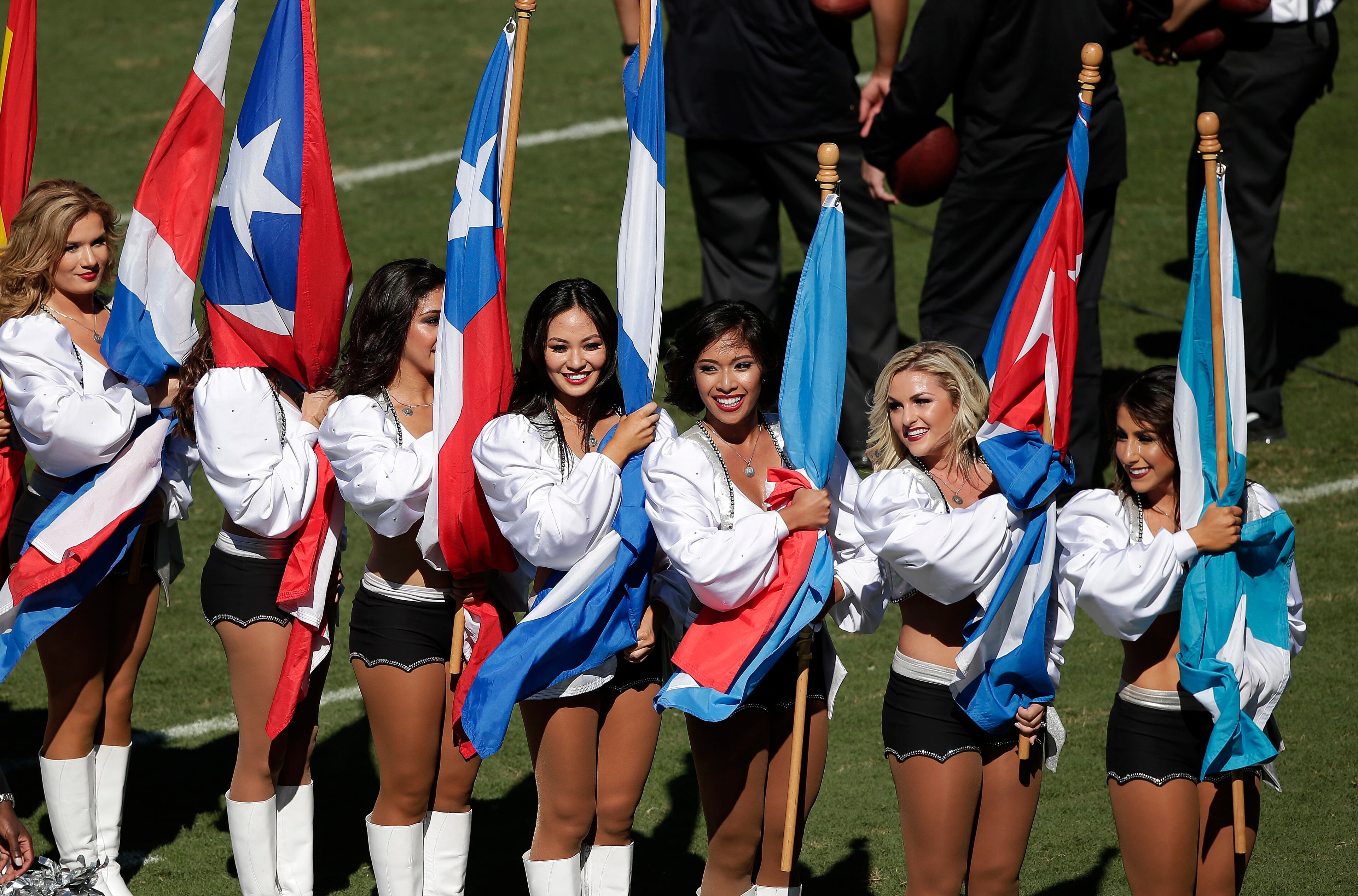 Oakland Raiders cheerleaders hold flags for Hispanic Heritage Month before an NFL football game between the Raiders and the Arizona Cardinals in Oakland, Calif., Sunday, Oct. 19, 2014. (AP Photo/Marcio Jose Sanchez)