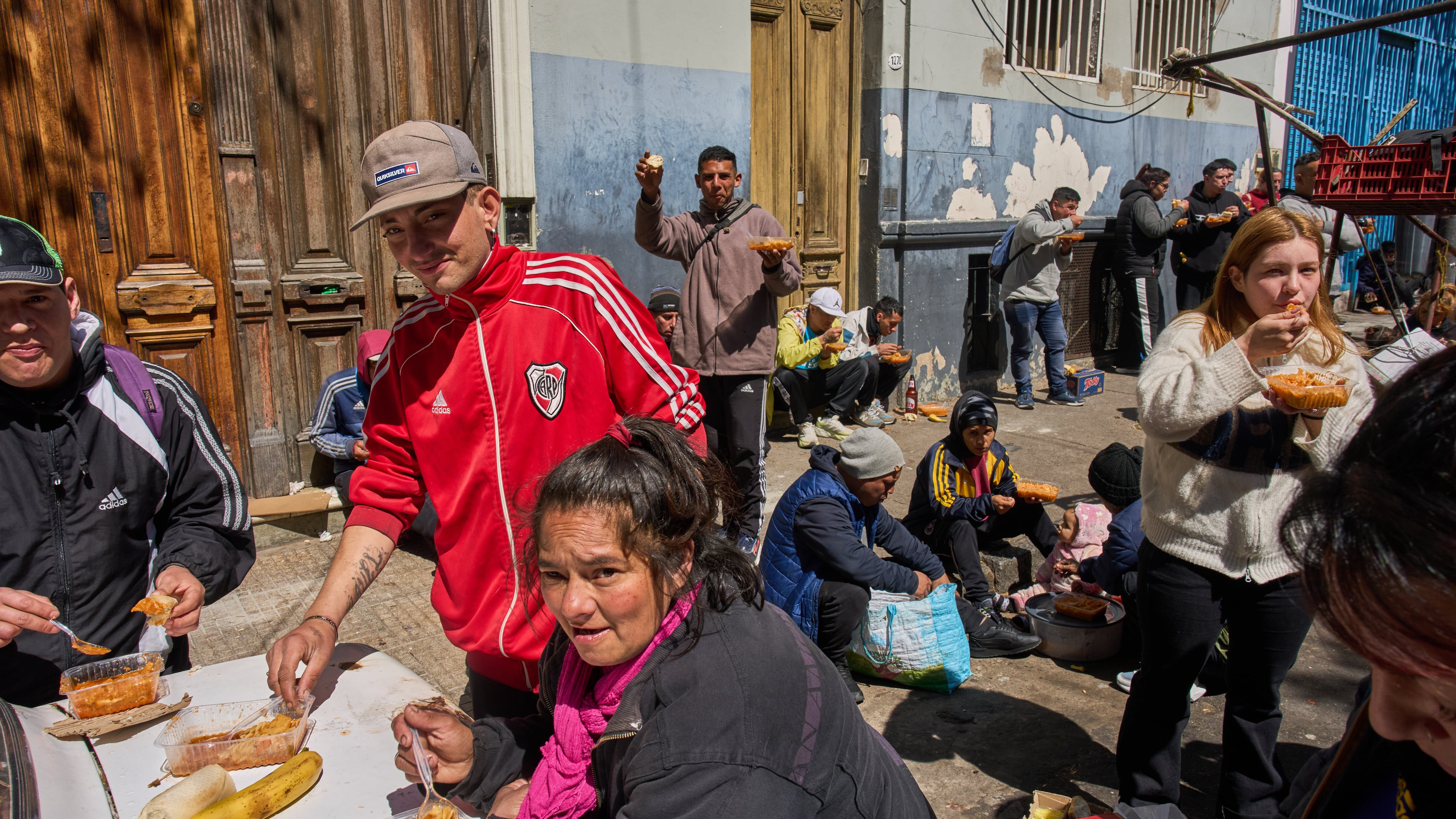 People eat food distributed for free by the Union of Workers of the Popular Economy in Buenos Aires, Argentina, Wednesday, Sept. 23, 2026. (AP Photo/Rodrigo Abd)