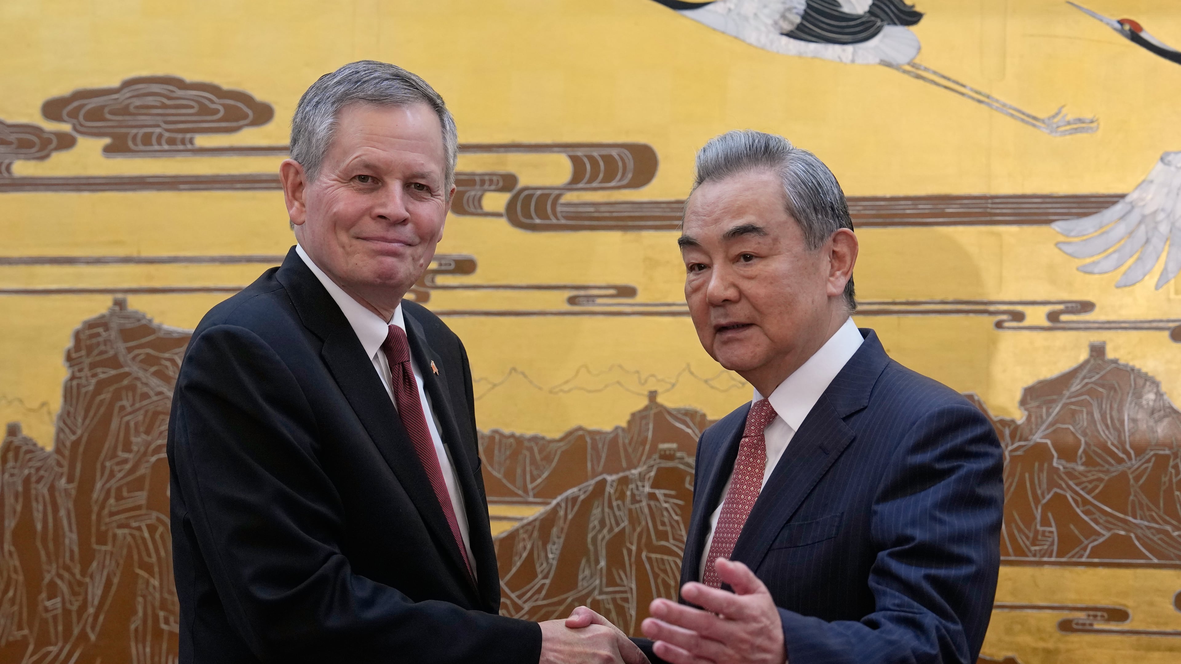 U.S. Senator Steve Daines, left, is greeted by Chinese Foreign Minister Wang Yi during a U.S. congressional delegation visit at the Great Hall of the People, in Beijing, Thursday, May 7, 2026. (AP Photo/Andy Wong, Pool)