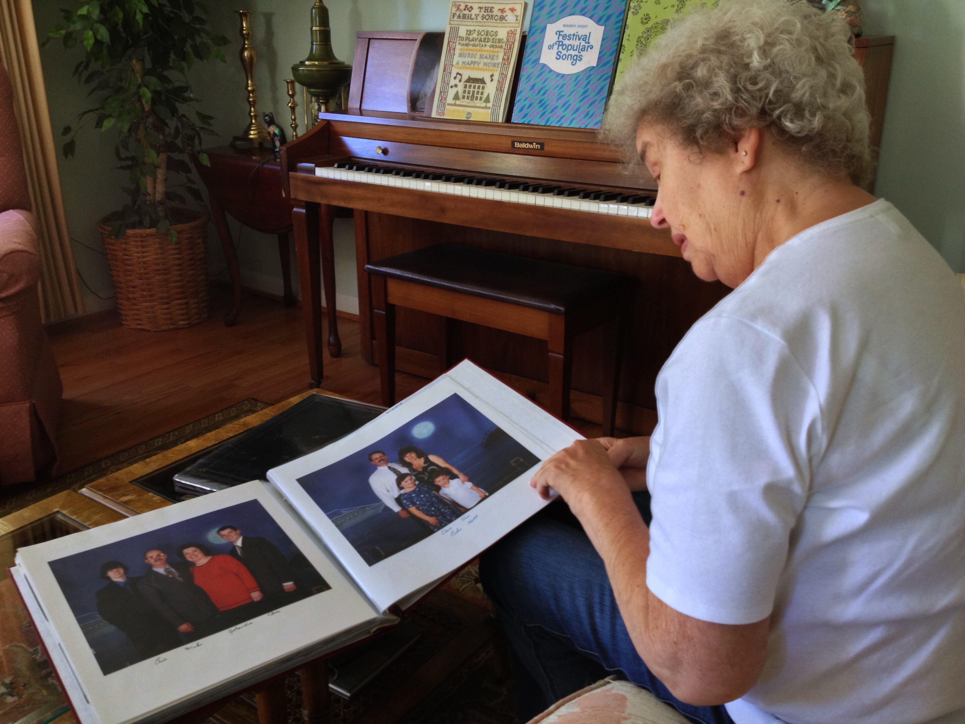 Patricia Arnold, of Rochester, Mich., looks at family photos, that include her son Michael Arnold on Tuesday, Sept. 17, 2013. Michael Arnold, 59, was shot and killed during the shooting rampage at the Washington Navy Yard on Monday. (AP Photo/Detroit News, Lauren Abdel-Razzaq)