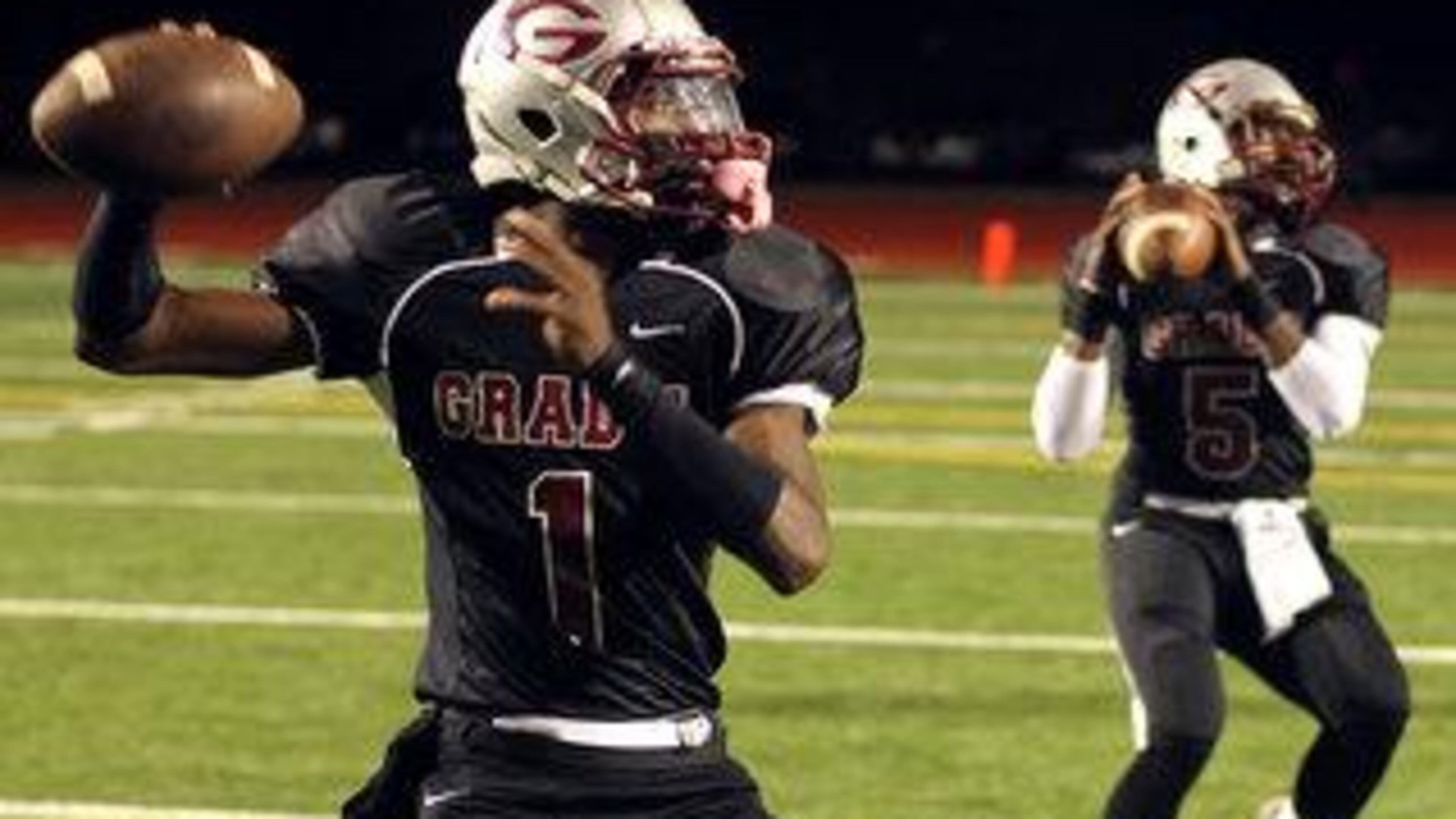 Damian Swann (1) & Treveon Albert (5) of Grady simultaneously prepare to throw a pass during pre-game warmups before the start of their region playoff game with Cedar Grove on Friday Nov. 5, 2010. (AJC file photo)