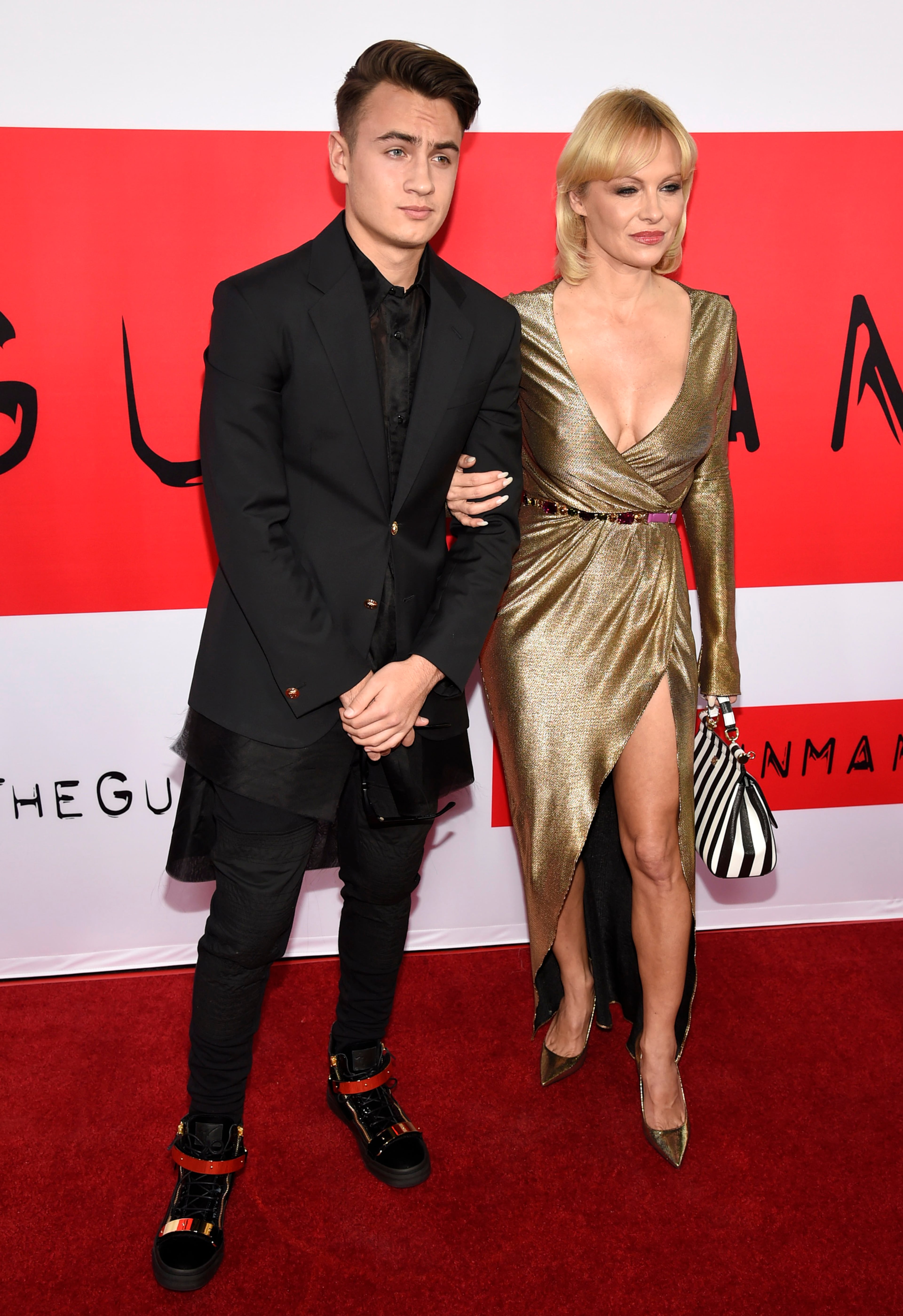 Brandon Thomas Lee, left, and Pamela Anderson arrive at the Los Angeles premiere of "The Gunman" at Regal Cinemas LA LIVE on Thursday, March 12, 2015. (Photo by Chris Pizzello/Invision/AP)