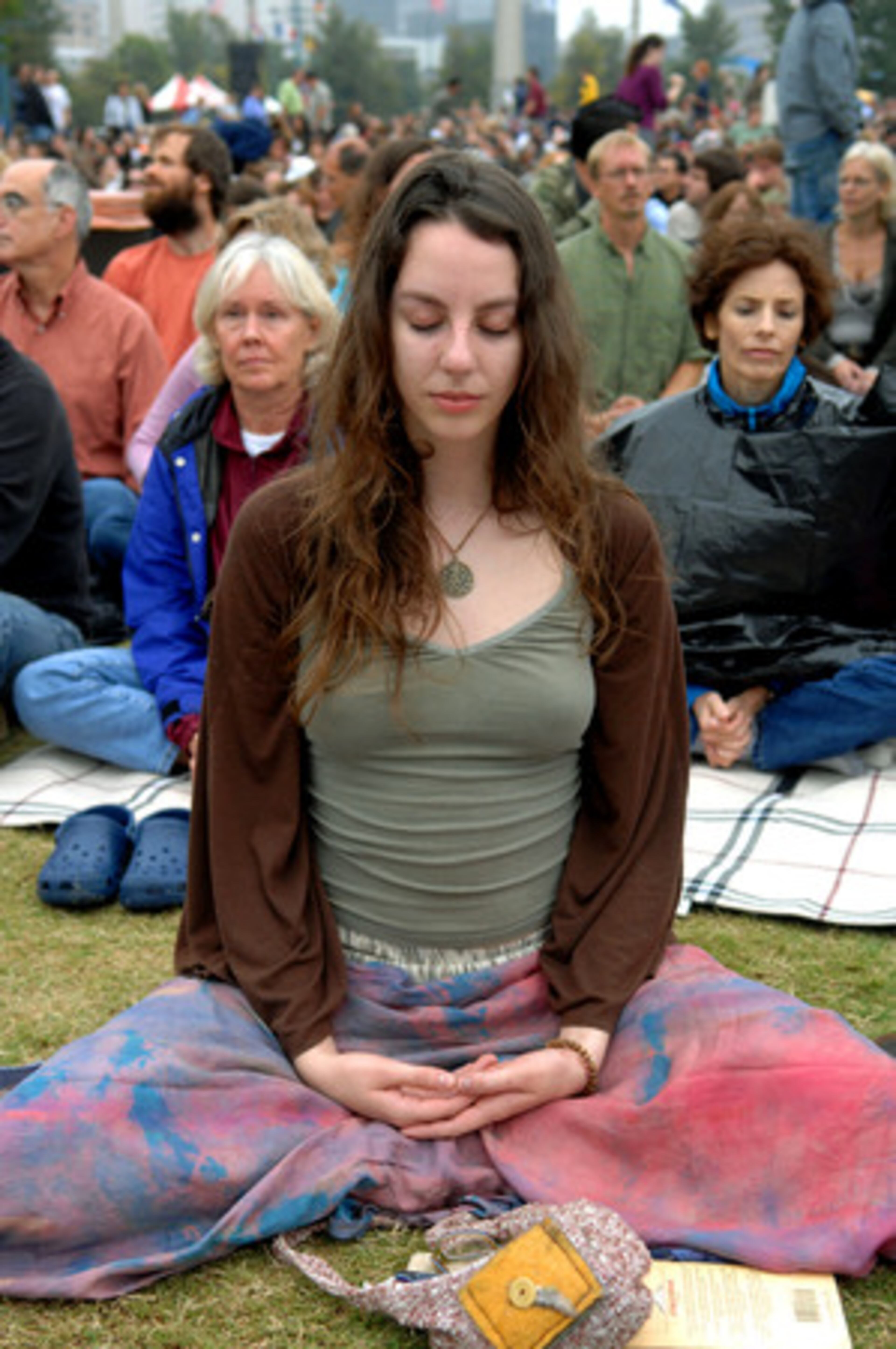Christina Grecchi of Savannah joins meditation as she waits for the Dalai Lama to arrive Monday at Centennial Olympic Park for a public talk, the last major item on his agenda while in Atlanta.