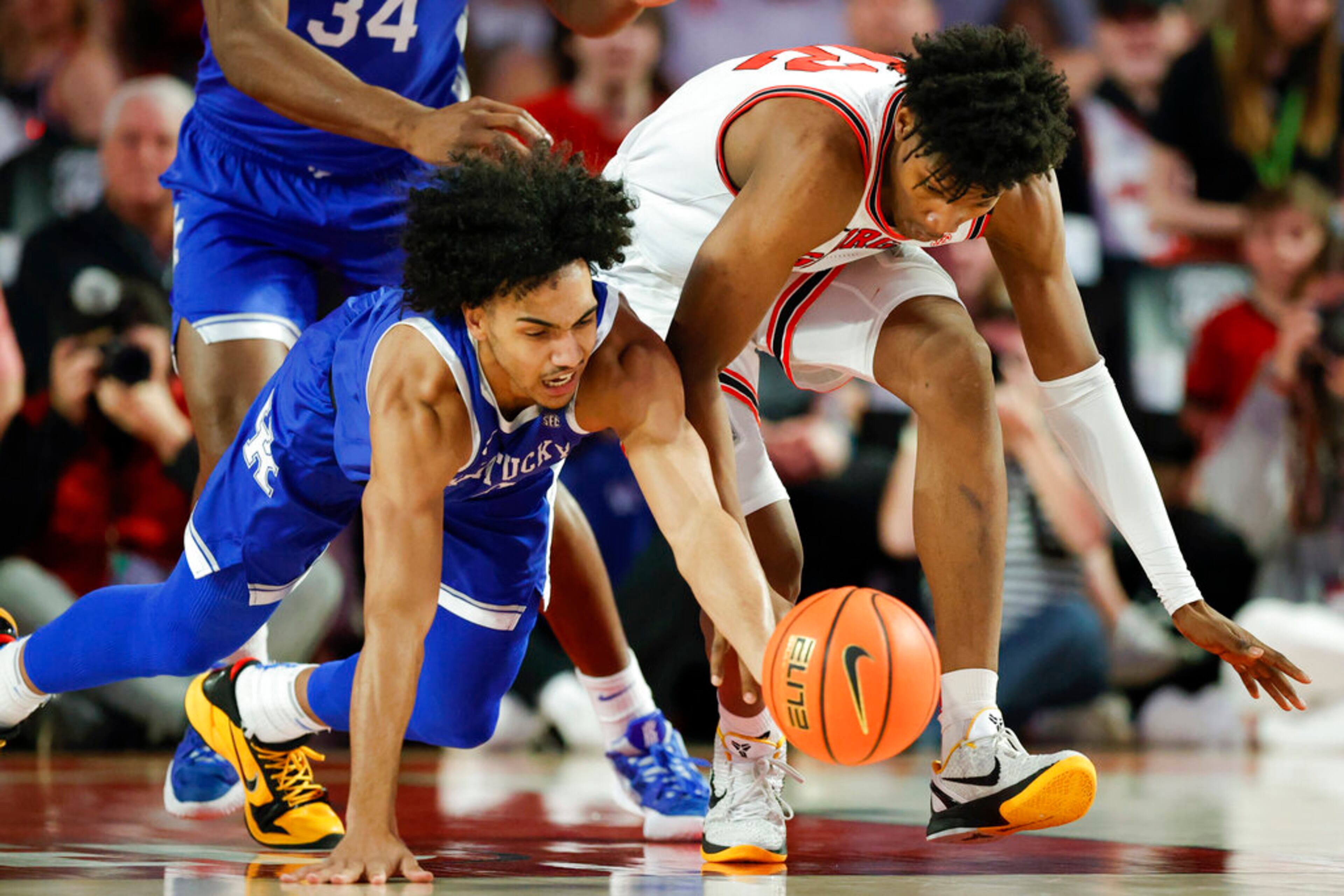 Kentucky forward Jacob Toppin, left, and Georgia forward Matthew-Alexander Moncrieffe, right, go after a loose ball during the first half of an NCAA college basketball game, Saturday, Feb. 11, 2023, in Athens, Ga. (AP Photo/Alex Slitz)
