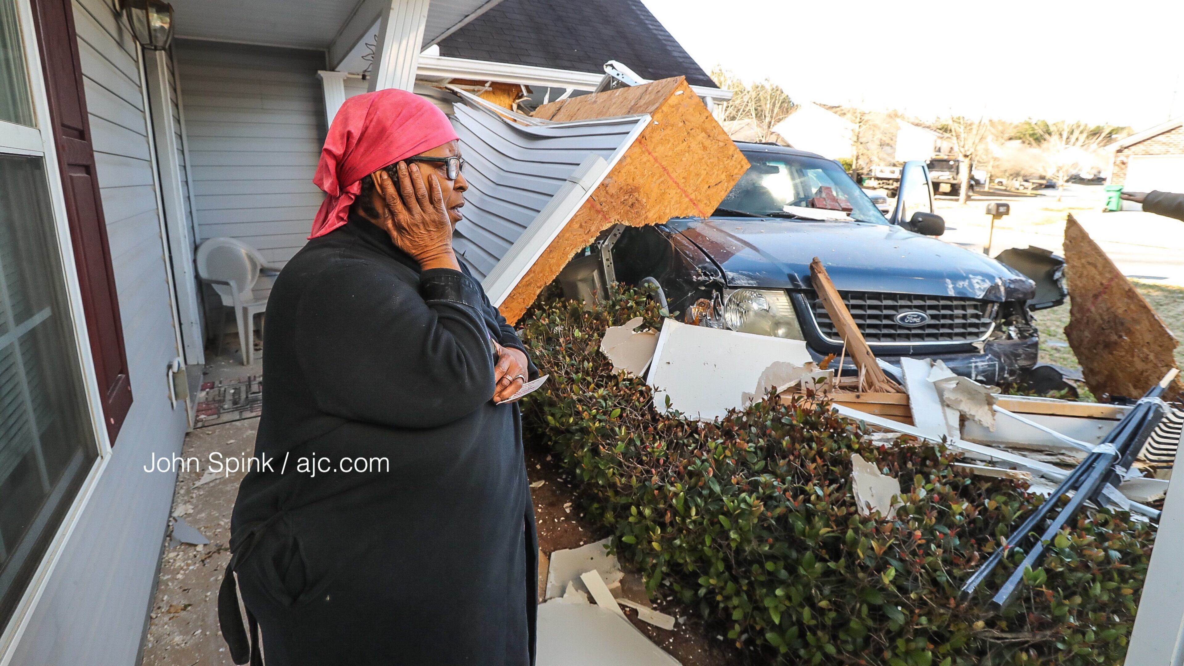 Carolyn Burgess surveys the damage after a stolen car crashed into her Browns Mill Ferry Road home Friday morning.