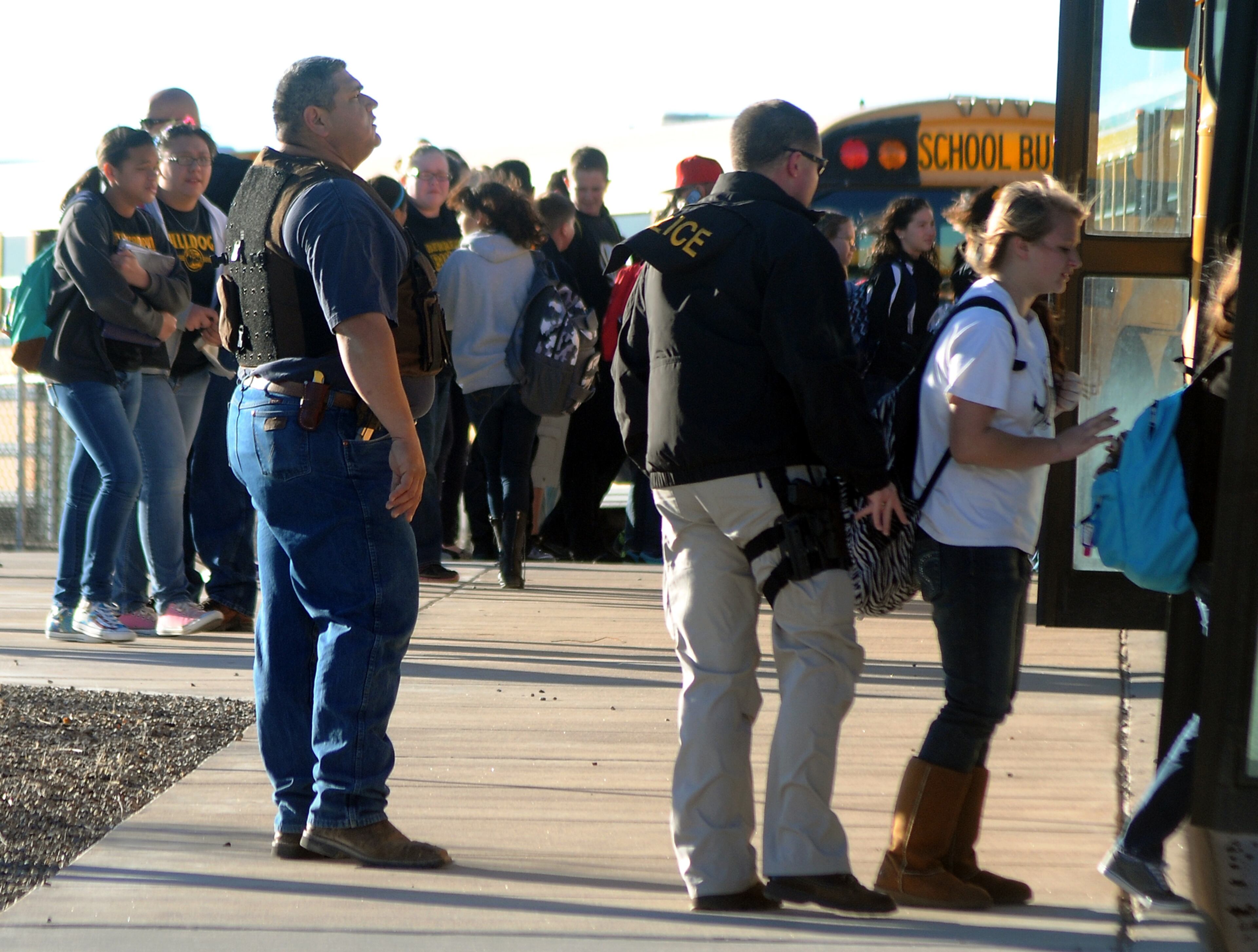 Authorities stand guard as students are escorted from Berrendo Middle School after a shooting on Jan. 14, 2014, in Roswell, N.M.