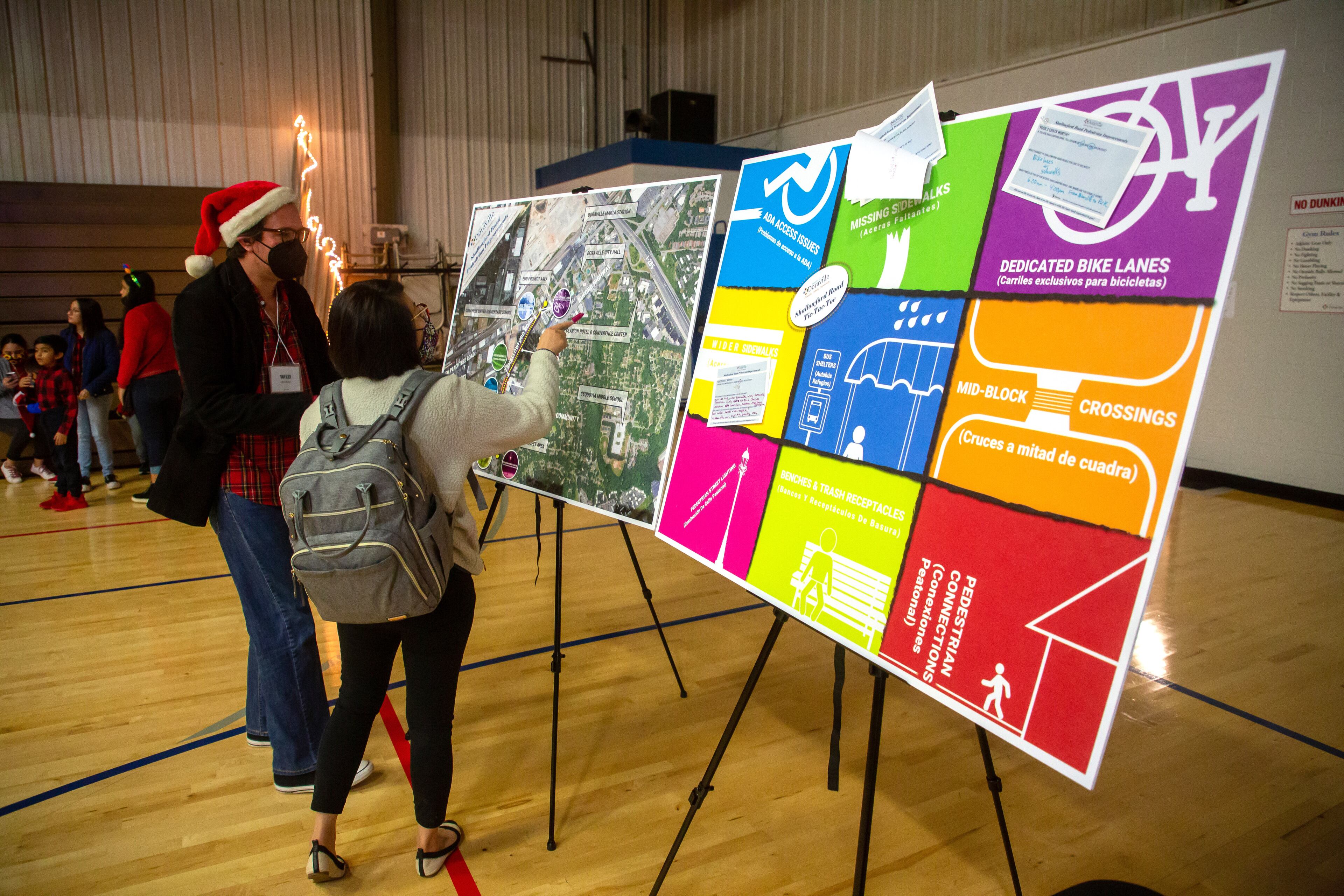 People look over the Shallowford Road pedestrian improvement map during the Doraville sesquicentennial grand finale celebration at the Forest Fleming Arena on Saturday, December 11, 2021. STEVE SCHAEFER FOR THE ATLANTA JOURNAL-CONSTITUTION