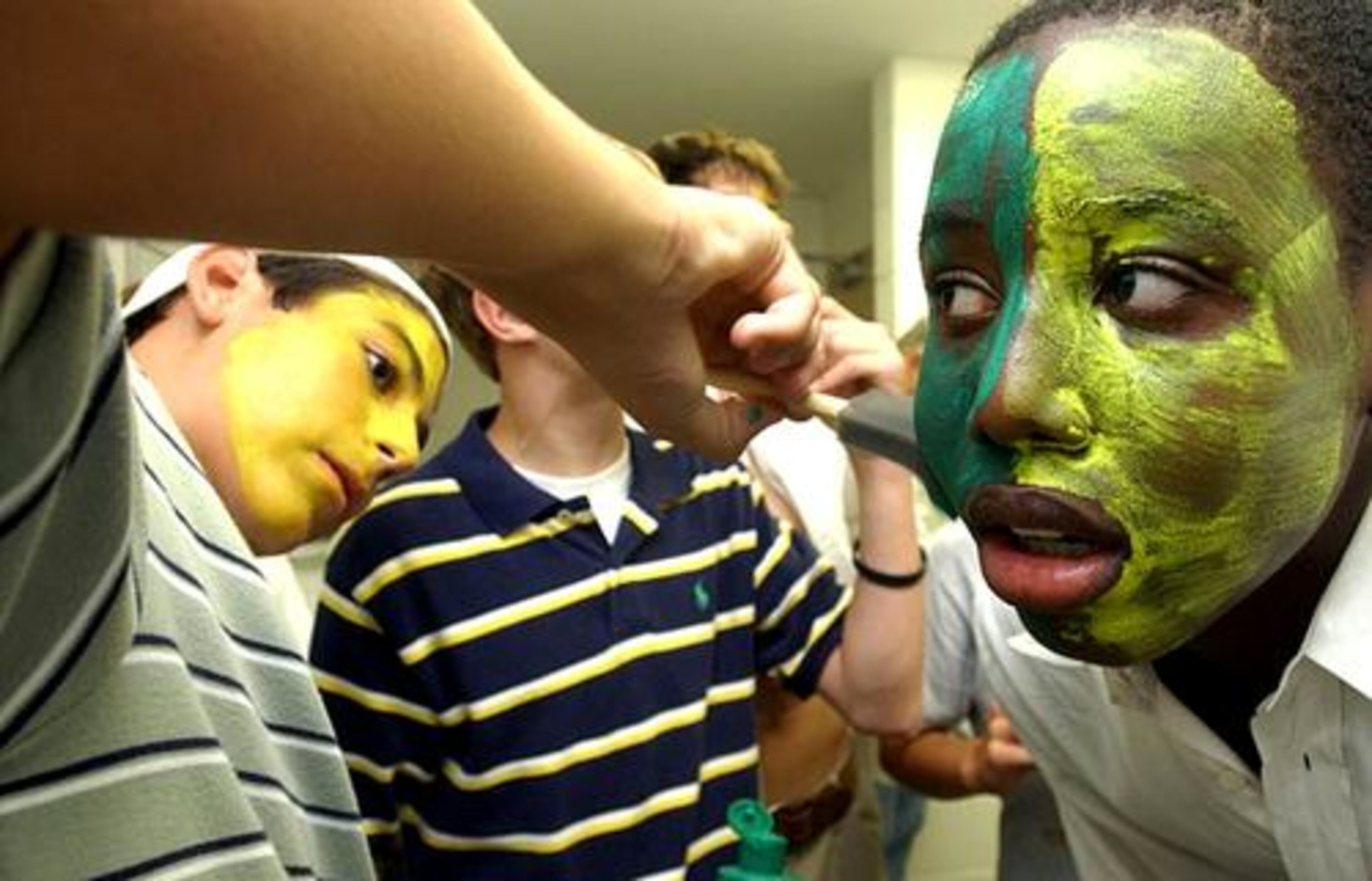 2004: Wesleyan freshman David Kaszycki, 15, paints up classmate Aminu, 13, as they prepare for a home football game against Greater Atlanta Christian. Aminu transferred from Wesleyan to Norcross in 2005.