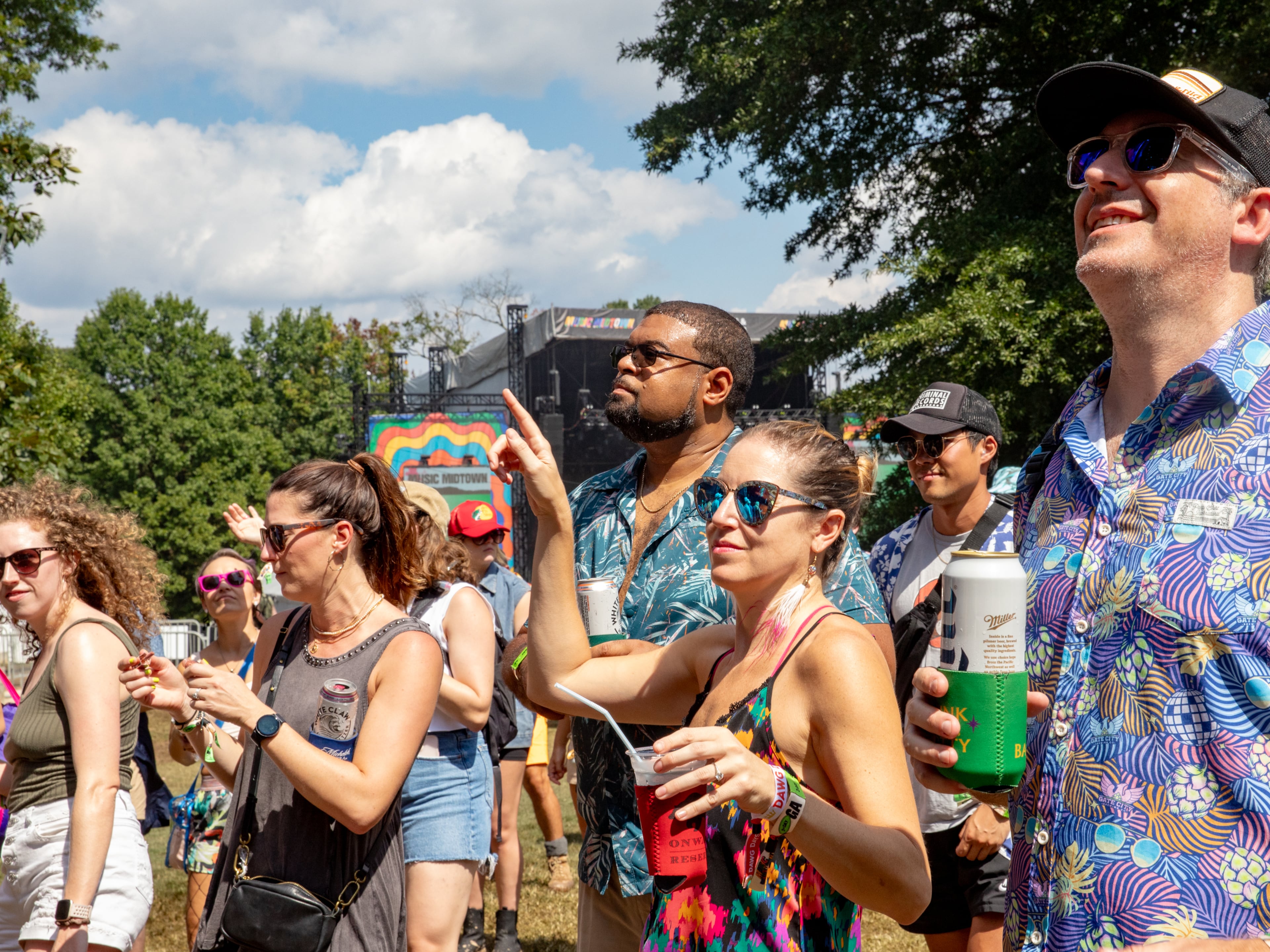 Magic City Hippies are on the Cotton Club stage at Music Midtown where Pate Slater, from right, Jenny Carbonell, and Torrence Welch enjoy the show with friends and other fans in Piedmont Park on Sunday, Sept 17, 2023. (Jenni Girtman for The Atlanta Journal-Constitution)