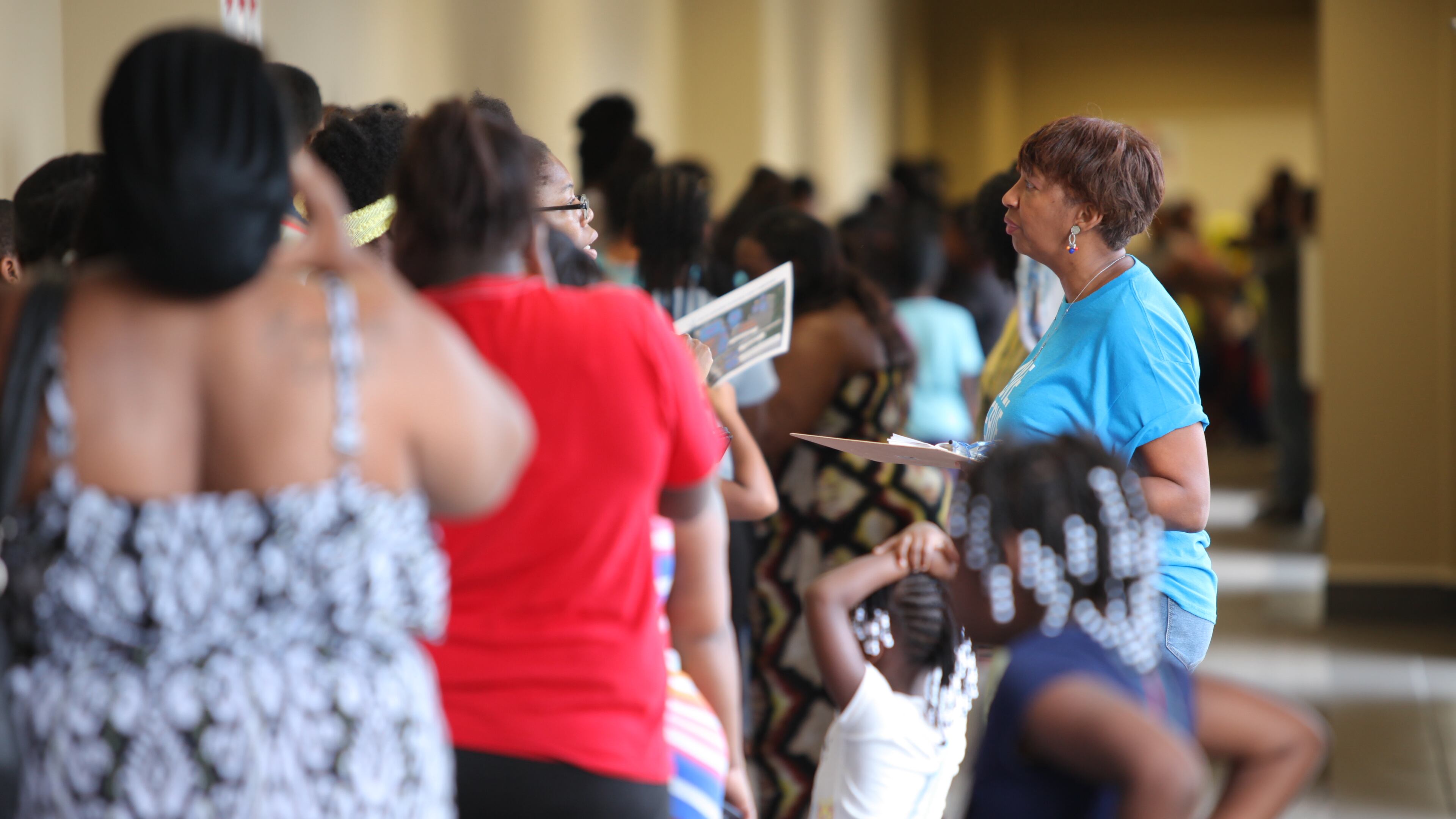 Parents and children line up to receive supplies and health screenings at World Changers Church International. CONTRIBUTED