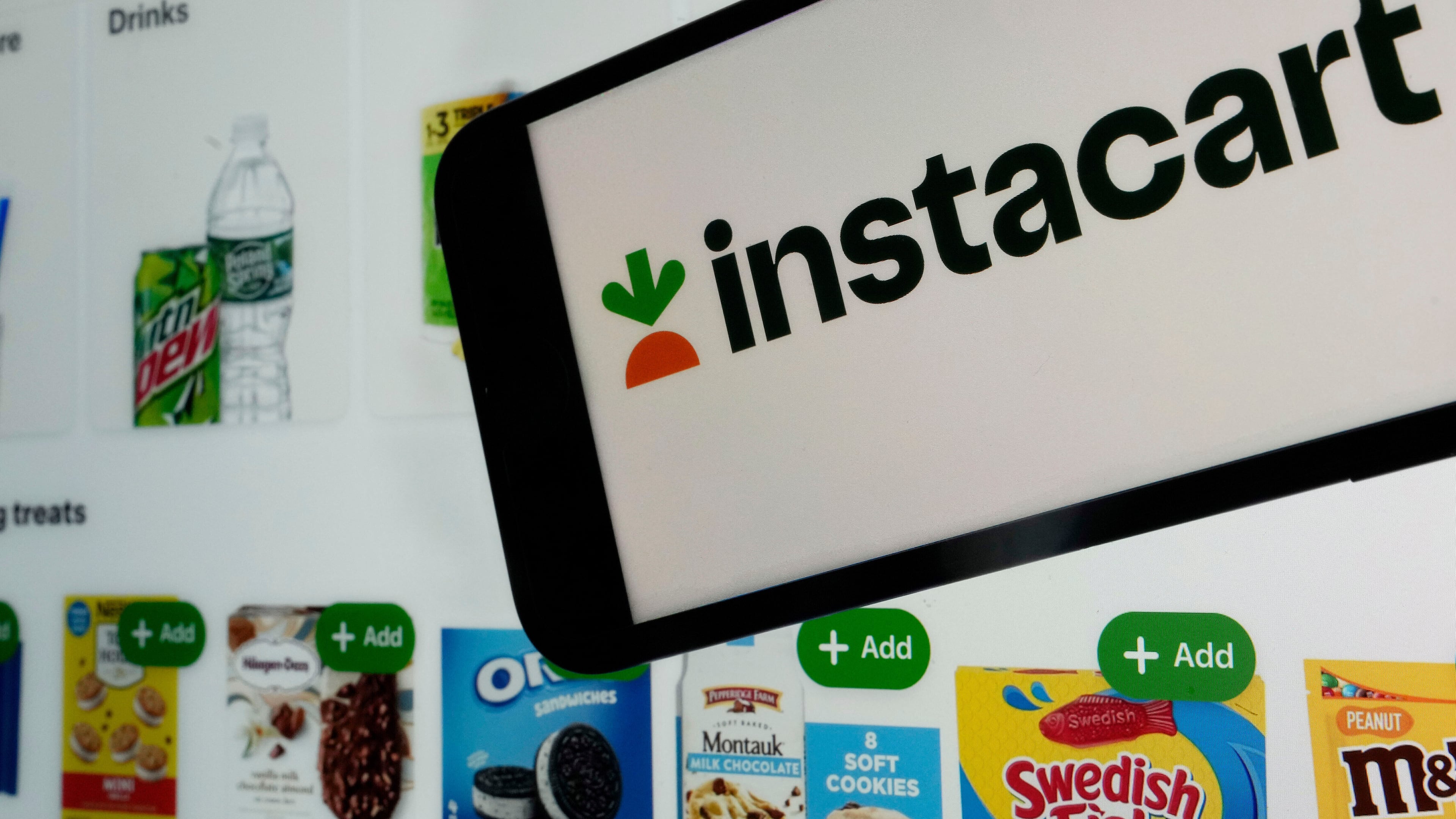 FILE - An instacart logo and an instacart webpage are seen in New York, Sept. 6, 2023. (AP Photo/Richard Drew, File)