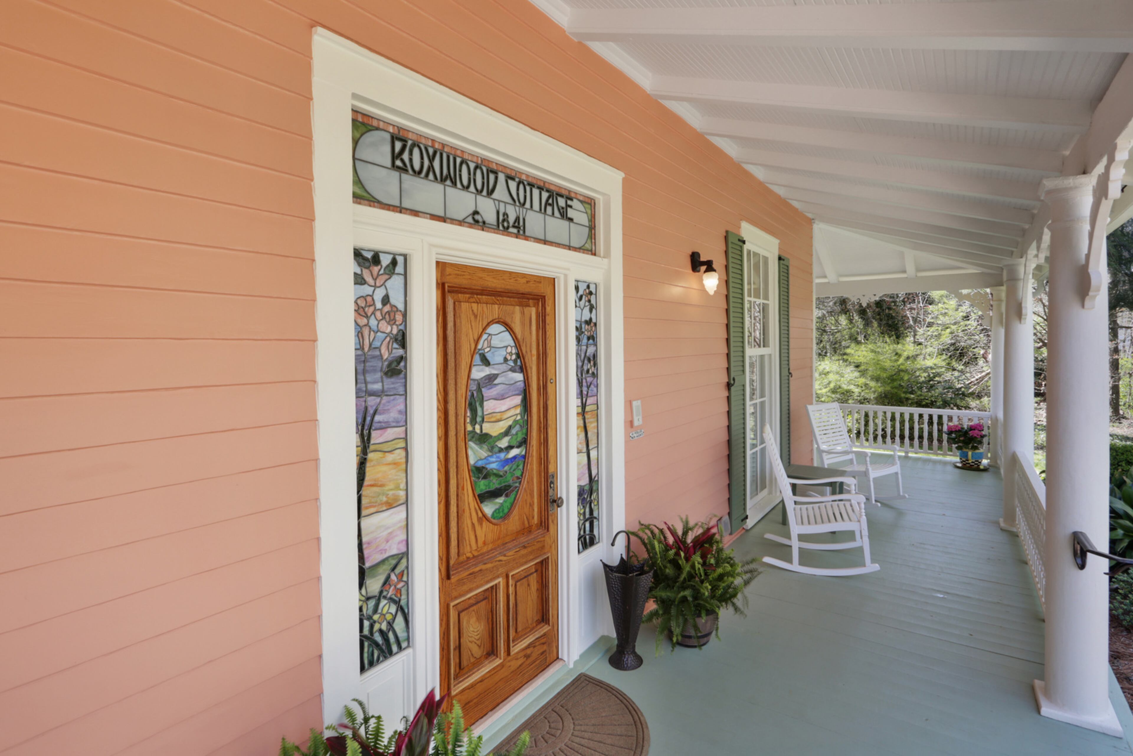 The custom stained glass around the front door proclaims the name of the home, Boxwood Cottage, built in 1841. Text by Jill Huitron