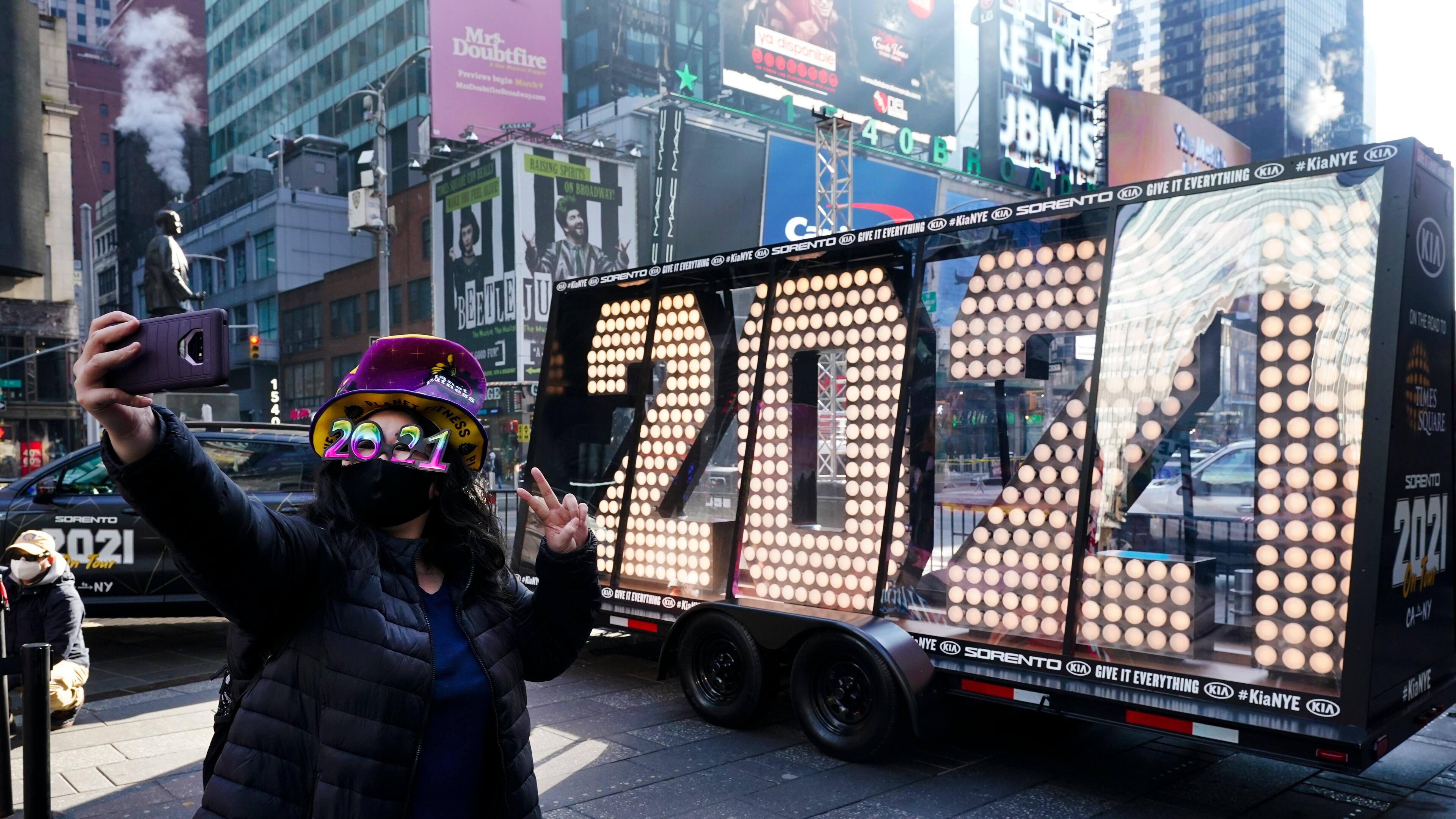 Teresa Hui, 39, poses for selfie photographs in front of the giant numerals for "2021" to be used in the upcoming New Year's eve festivities in New York's Times Square, Monday, Dec. 21, 2020. (AP Photo/Frank Franklin II)