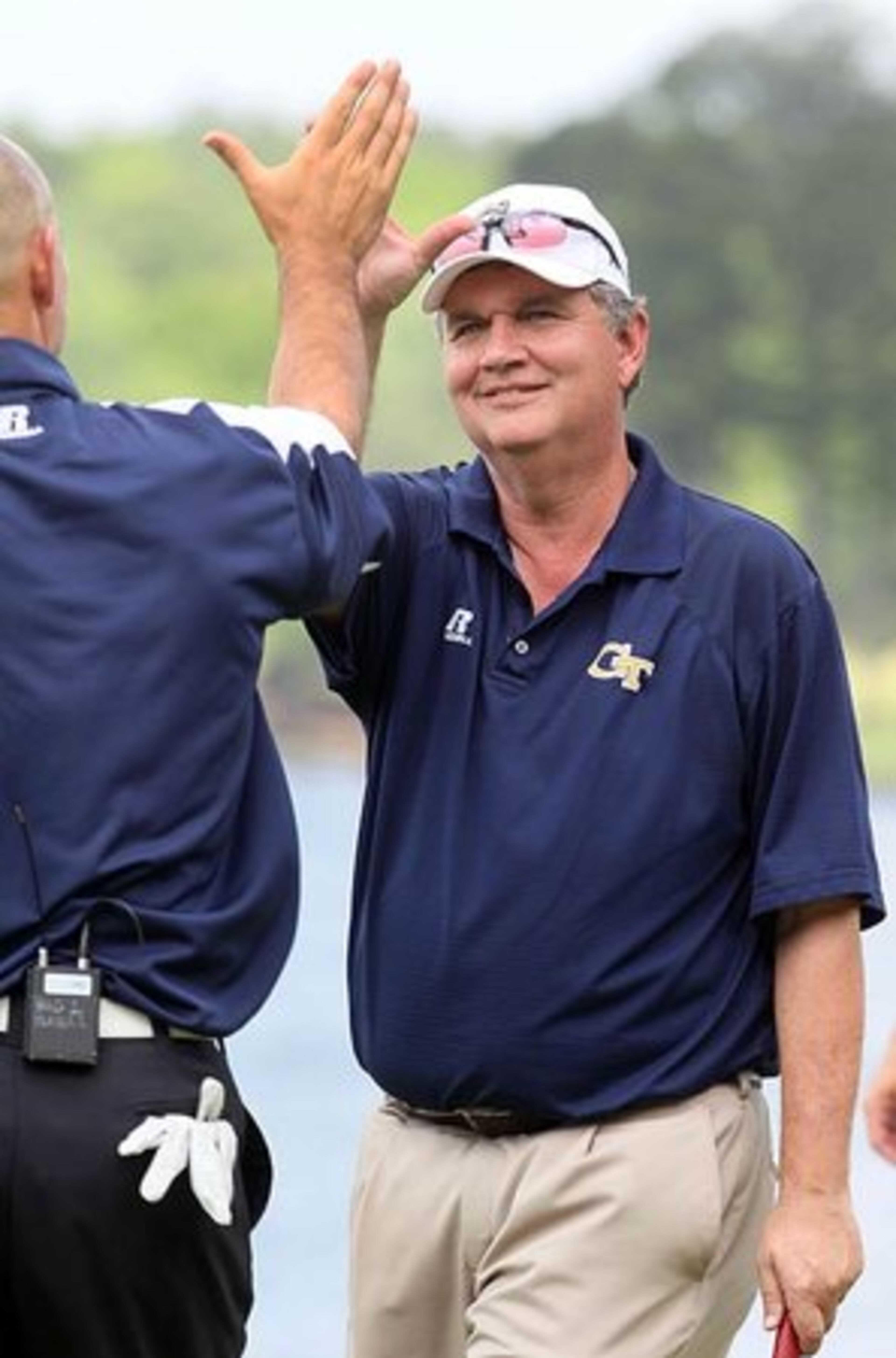 Georgia Tech's Jon Barry (left-back to camera) high fives head football coach Paul Johnson as they win the 2011 Chick-fil-A Bowl Challenge on the Oconee golf course at Reynolds Plantation in Greensboro, Ga., on Tuesday, May 3. Johnson and Barry earned $120,000 in scholarship money by winning the contest with an 11-under-par score.