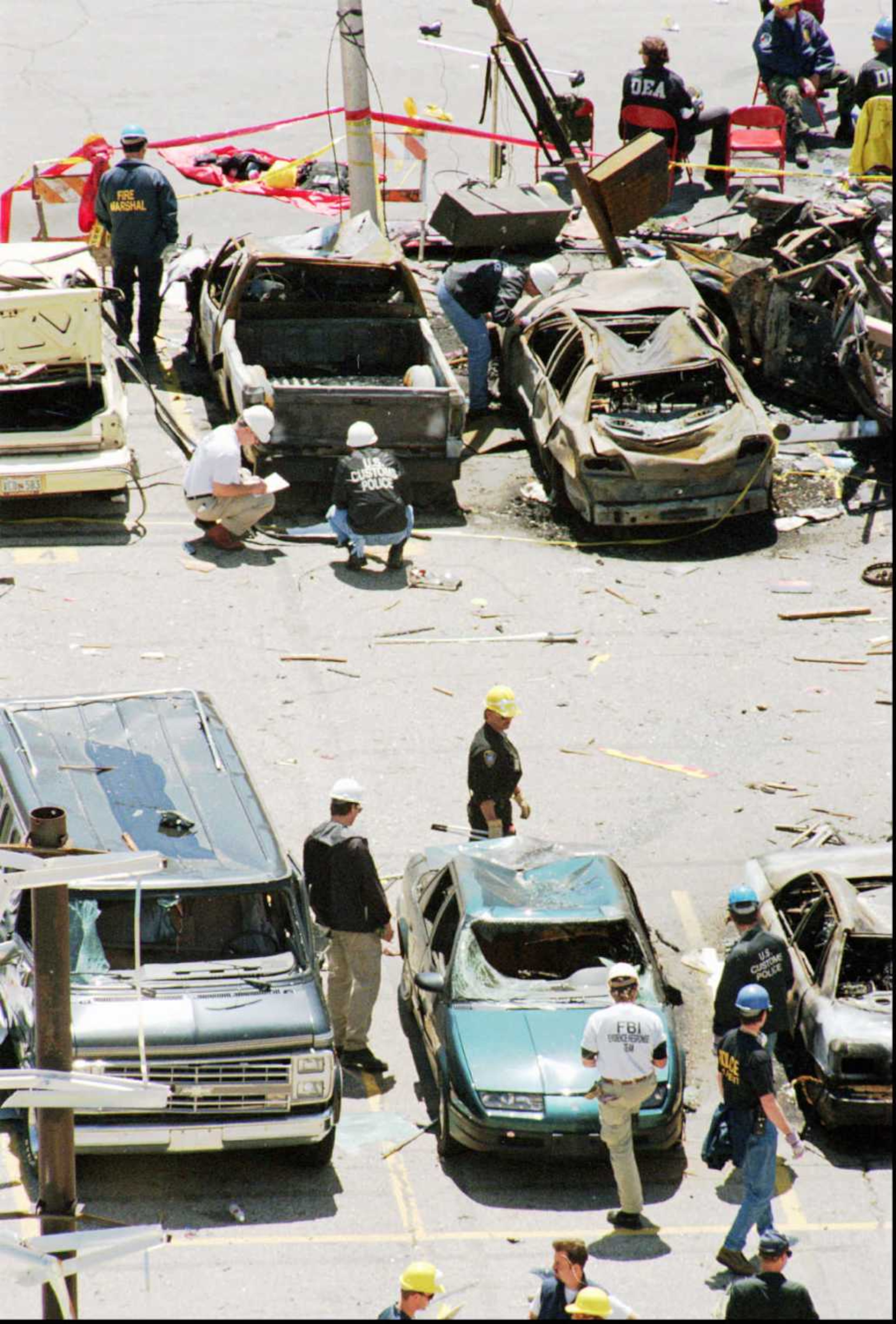 FBI ATF and U S Customs agents look carefully for car bomb evidence on and around destroyed cars north of the Alfred P Murrah Federal Building Thursday April 20 1995 in downtown Oklahoma City (AP Photo / The Daily Oklahoman / Paul Hellstern)