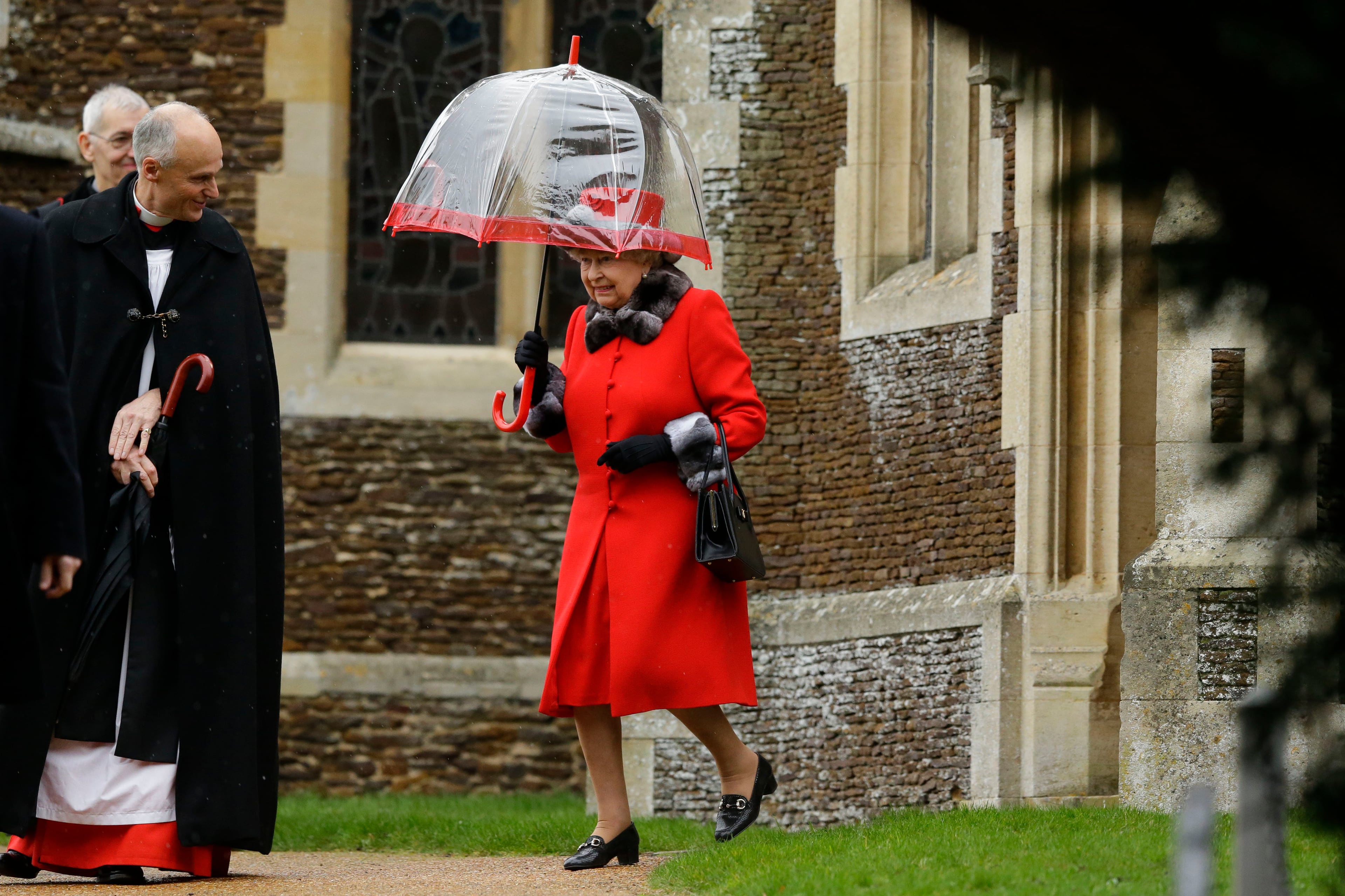Britain's Queen Elizabeth II shelters under an umbrella as she leaves, after attending the British royal family's traditional Christmas Day church service at St. Mary Magdalene Church in Sandringham, England, Friday, Dec. 25, 2015. (AP Photo/Matt Dunham)