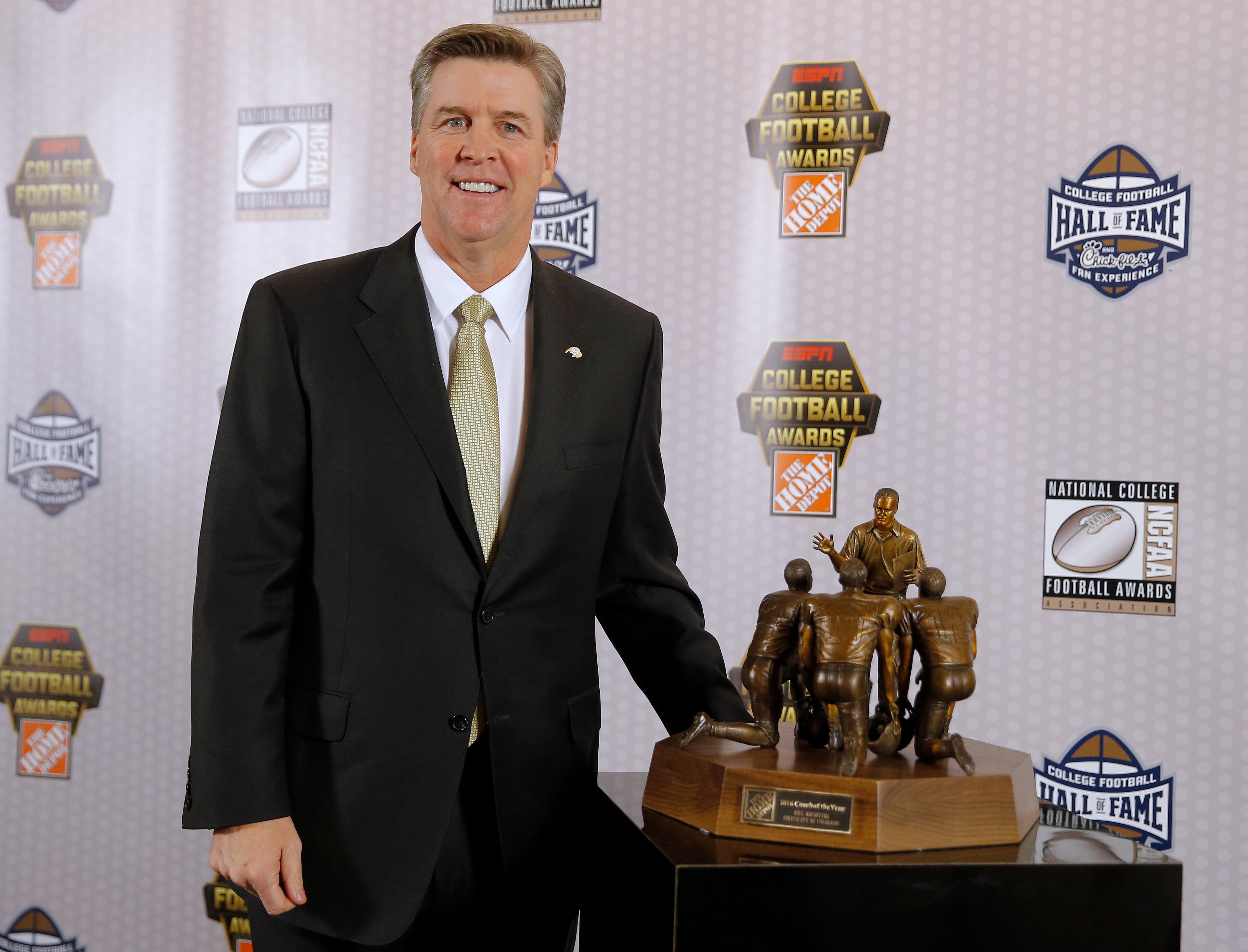 Colorado head football coach Mike MacIntyre poses with the Home Depot Coach of the Year Award after being the best coach in college football Thursday, Dec. 8, 2016, in Atlanta. (AP Photo/John Bazemore)