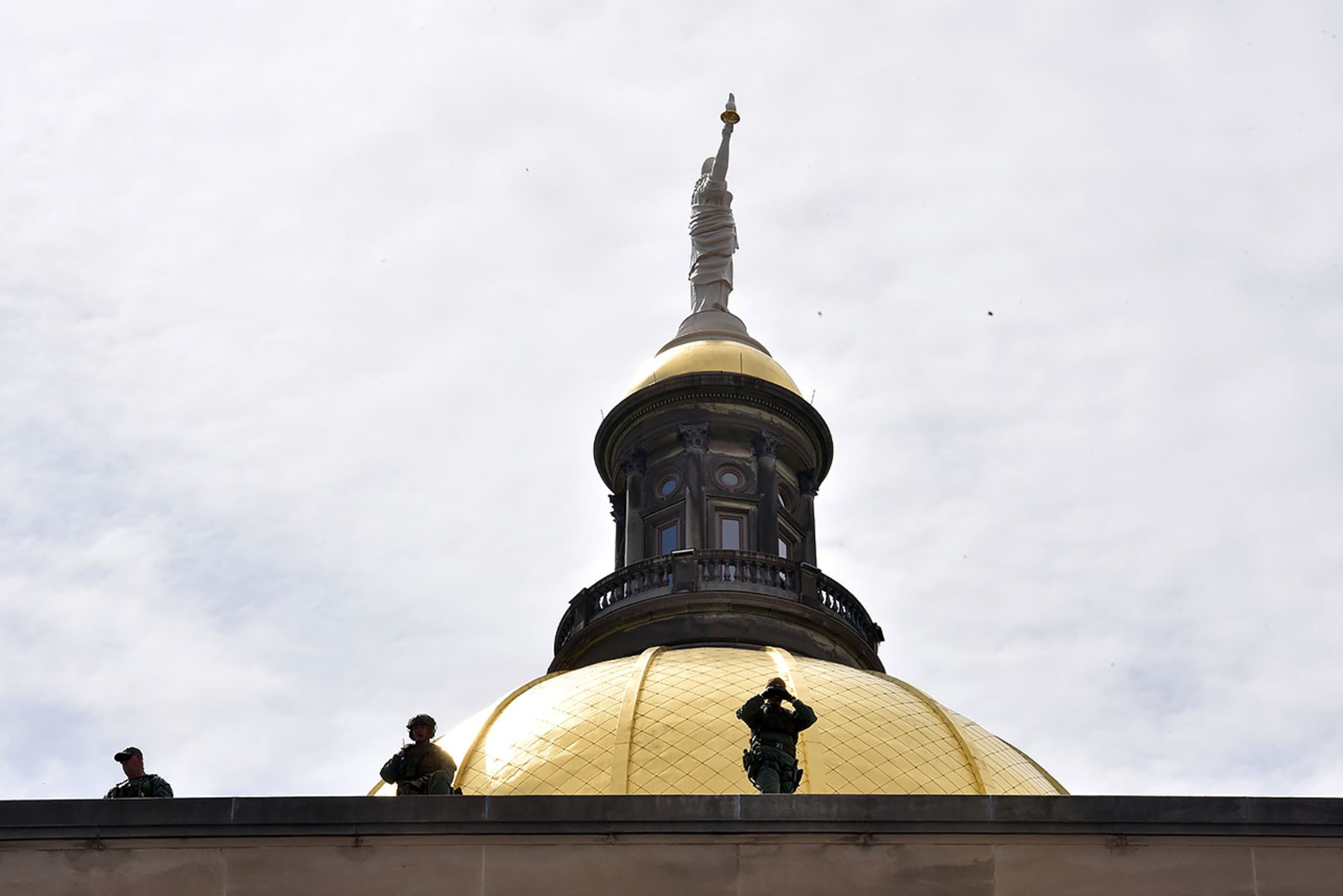 March 24, 2018 Atlanta - Law enforcement officers monitor from the rooftop of the Georgia State Capitol as thousands of people march to Liberty Plaza during the March For Our Lives rally in downtown Atlanta on Saturday, March 24, 2018. Atlanta police estimated the crowd at near 30,000 for todayâÃôs March for Our Lives. People of all ages were drawn to one of the nationwide demonstrations in a movement begun by student survivors of last monthâÃôs mass killing in a Parkland, Fla., school. Some of those Florida students were among the speakers in Atlanta. HYOSUB SHIN / HSHIN@AJC.COM