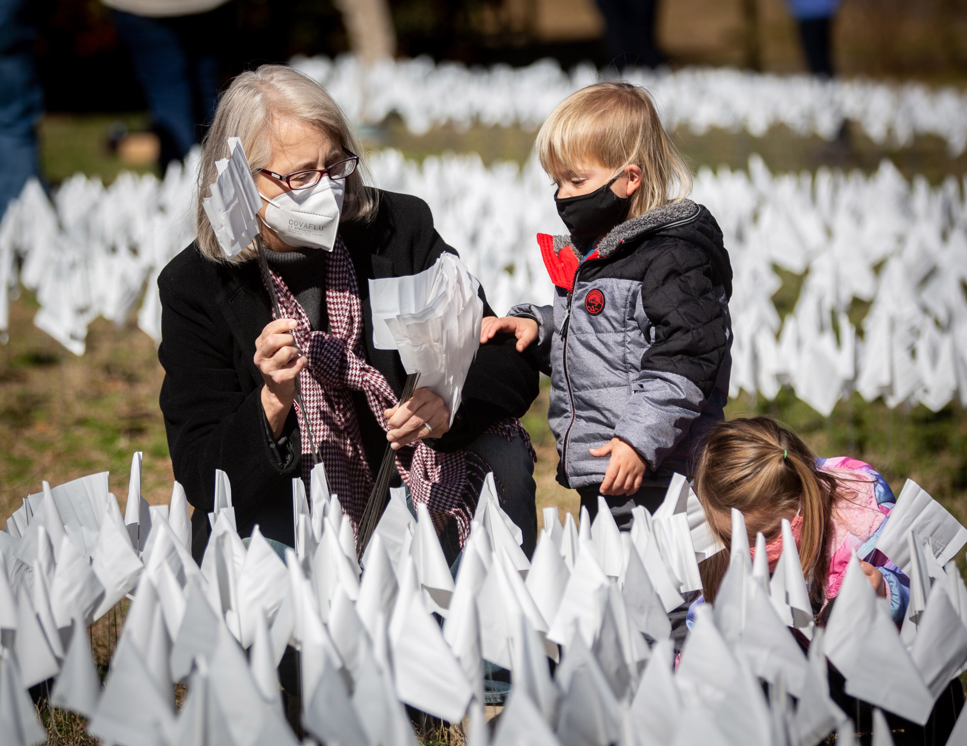 State Rep. Karla Drenner helps her son Francis plant some of the 15,000 white flags on the lawn of First Christian Church of Decatur on Saturday, February 20, 2021. The flags represent the number of COVID-19 deaths in Georgia, and the effort aims to raise awareness about the toll of the coronavirus. (Photo: Steve Schaefer for The Atlanta Journal-Constitution)