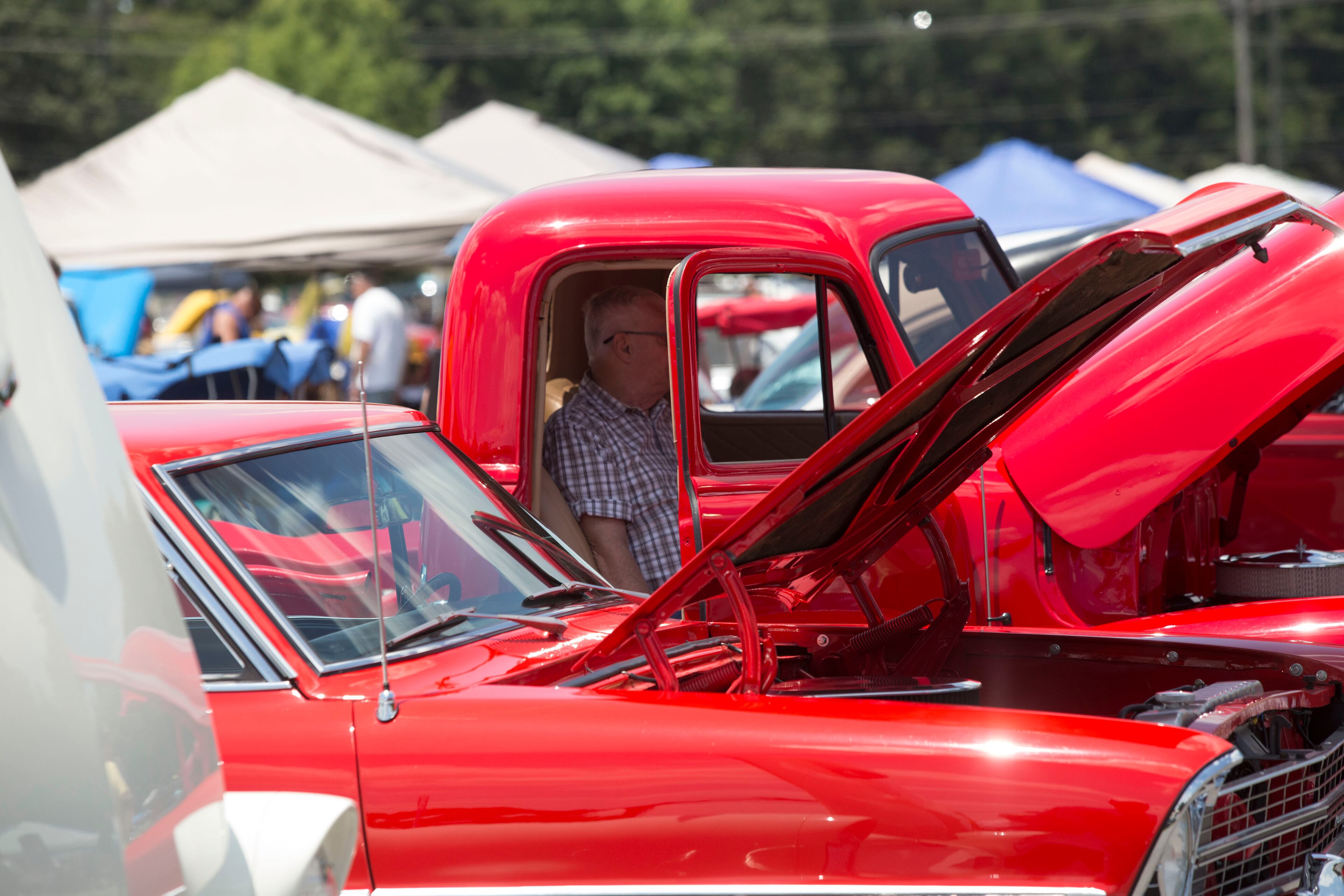 A man sits in a truck within a pool of other vibrant red retro vehicles at the 27th annual Creepers Car Club Fun Run show, on Saturday June 10, 2017. Hundreds of classic cars and trucks were on display at the Fun Run. The event, which began at 9 a.m., included music, food and a swap meet. Chad Rhym/ chad.rhym@ajc.com