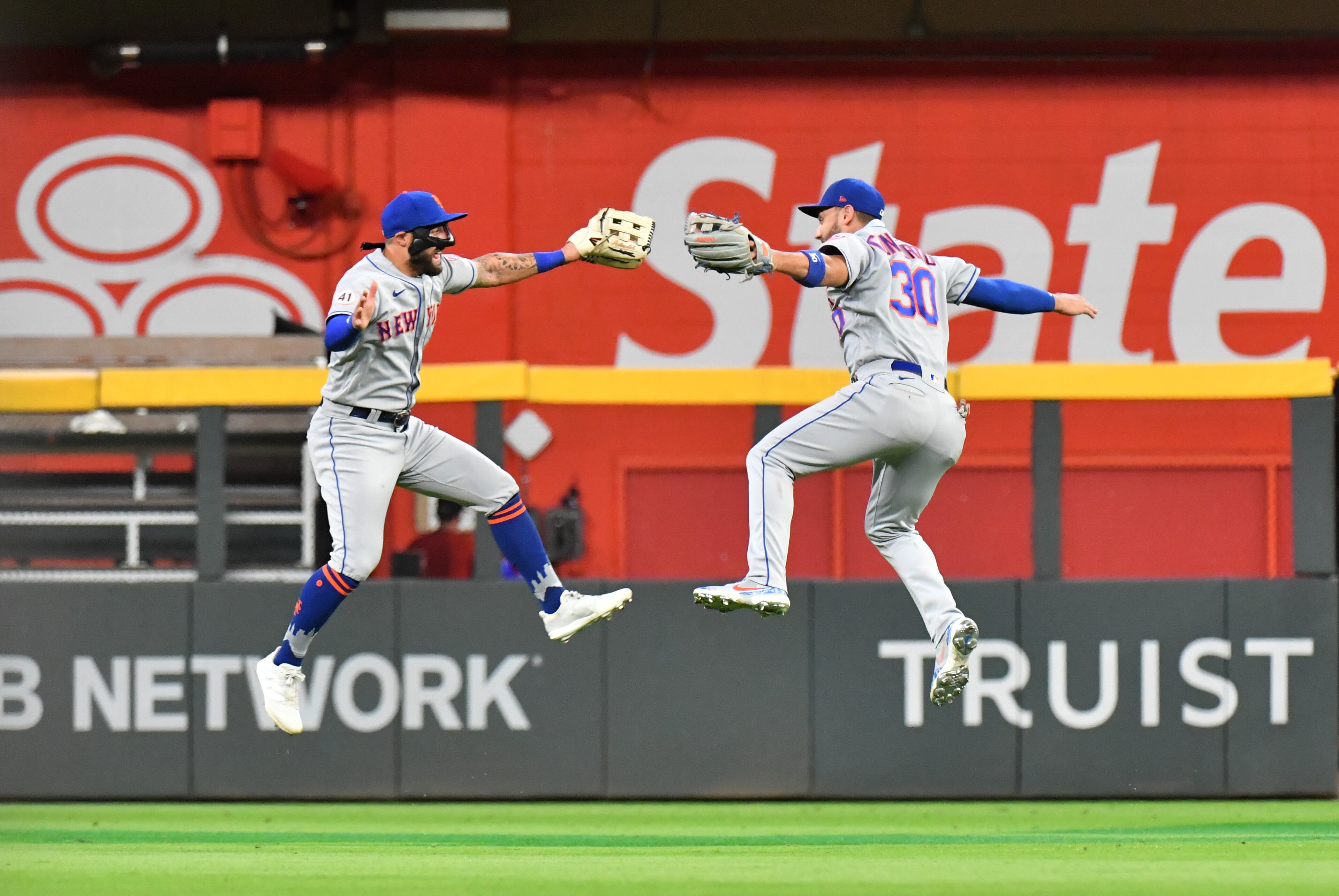 Mets outfielders Kevin Pillar (11) and Michael Conforto (30) celebrate at the end of Tuesday's 4-3 victory over the Braves at Truist Park.