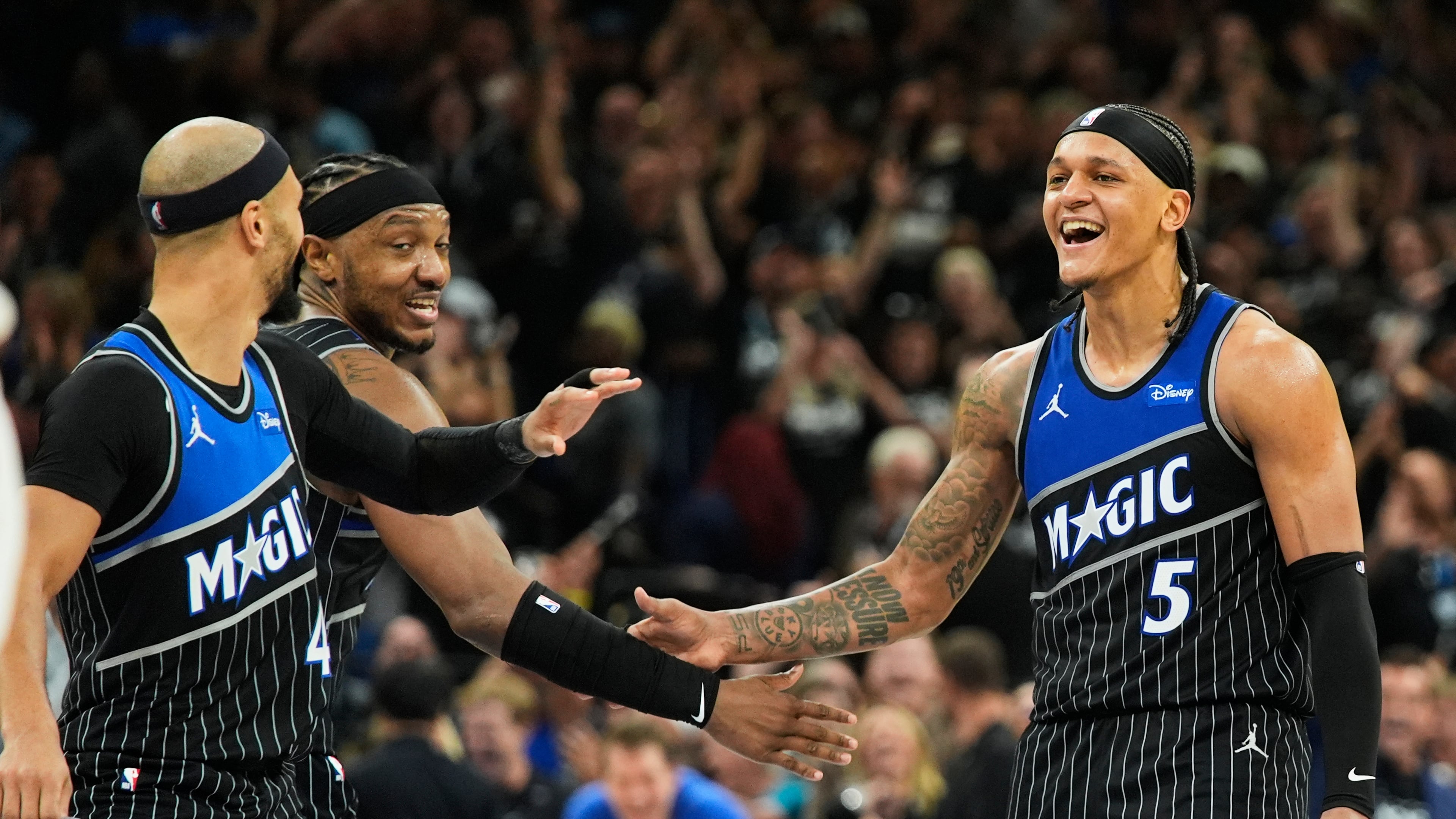 Orlando Magic forward Paolo Banchero (5) celebrates with teammates guard Jalen Suggs, left, and center Wendell Carter Jr. after sinking a 3-point shot against the Detroit Pistons during the closing moments of the second half in Game 3 of a first-round NBA basketball playoff series, Saturday, April 25, 2026, in Orlando, Fla. (AP Photo/John Raoux)