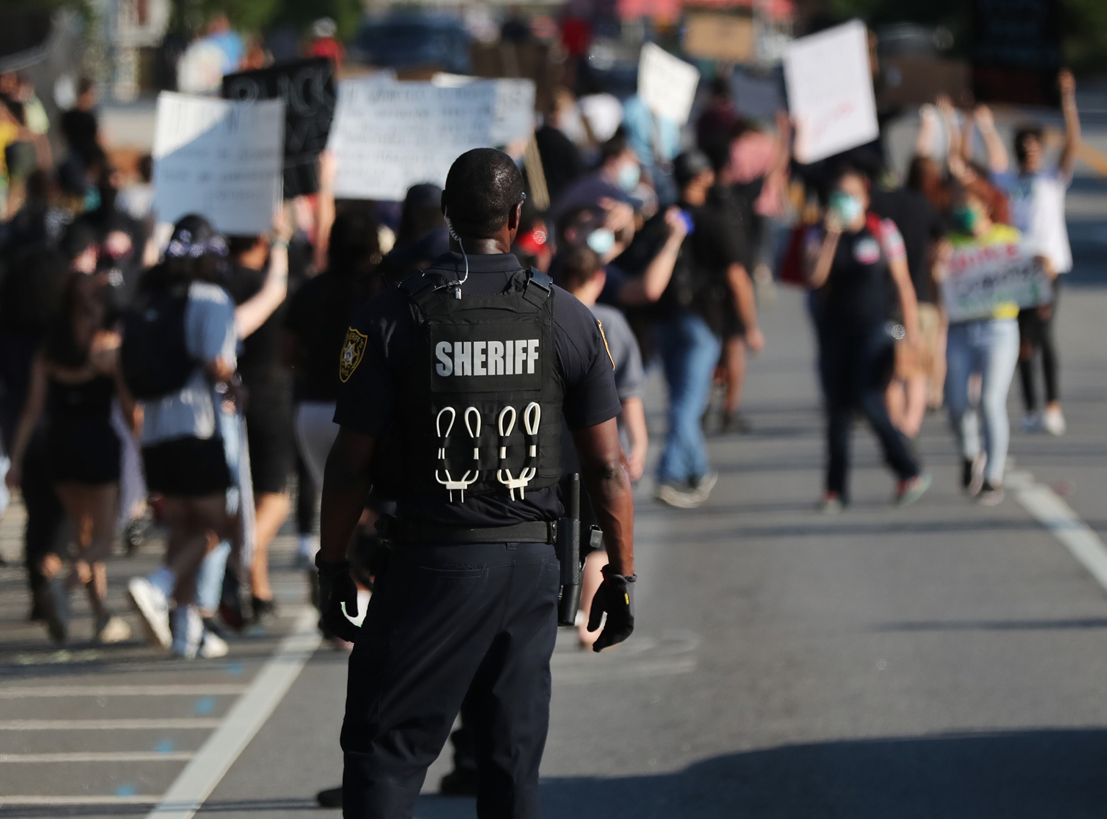 060120 Lawrenceville: A law enforcement official watches over protesters on South Clayton Street a few blocks from Lawrenceville City Hall during a fourth day of unrest around metro Atlanta over the death of George Floyd on Monday, June 1, 2020, in Lawrenceville. Curtis Compton ccompton@ajc.com